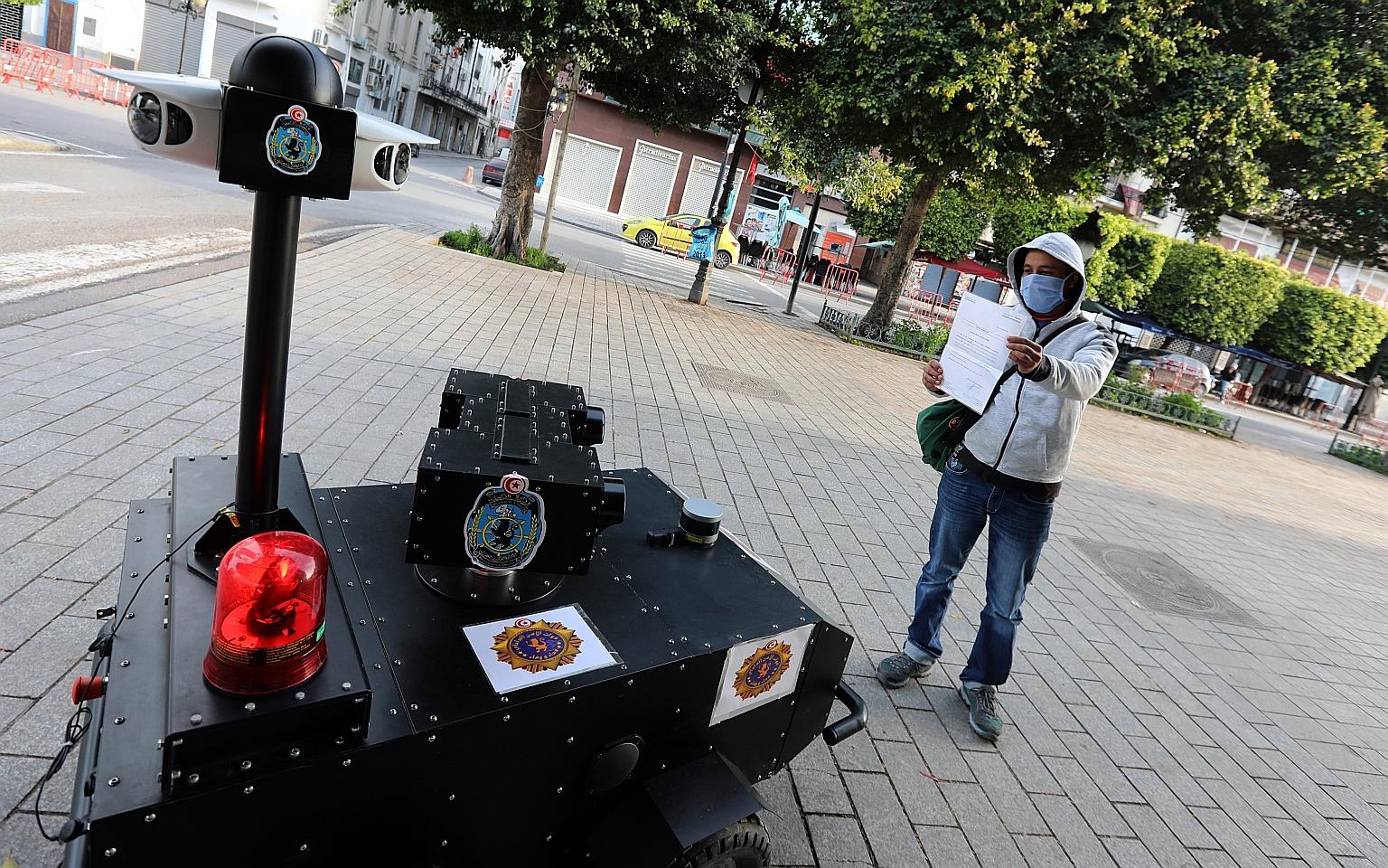A Tunisian Police P-Guard robot checking the exit permit of a citizen while calling on residents to respect a quarantine order, in Tunis this week. PHOTO: EPA-EFE