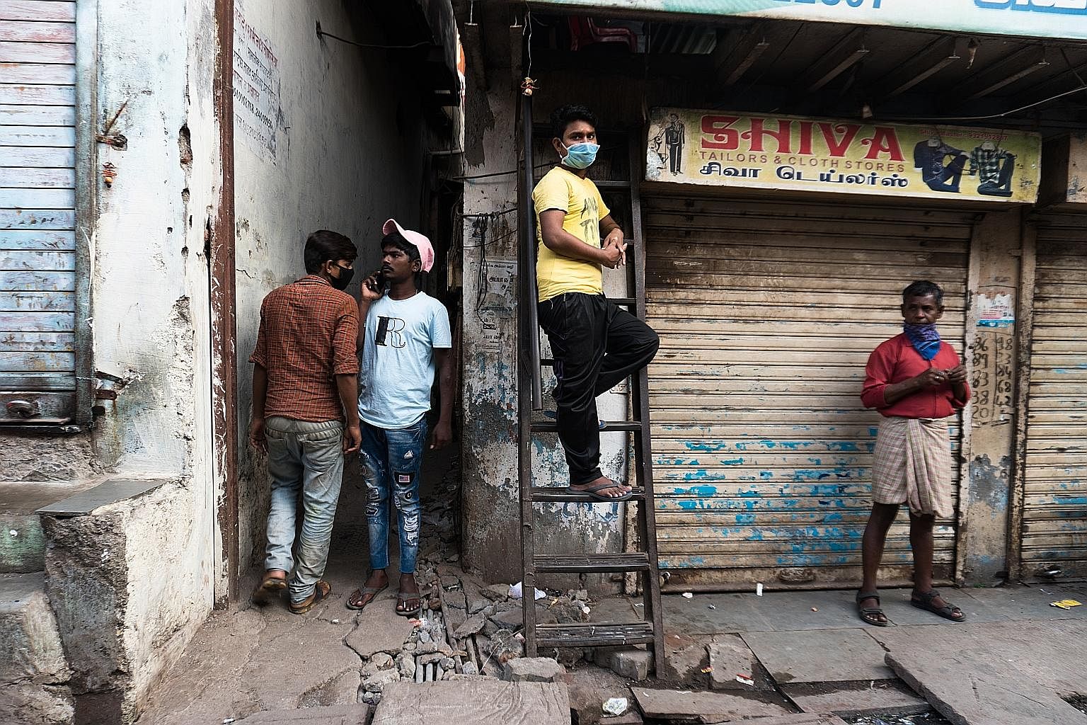 Above: Residents in Dharavi, a slum in Mumbai, keeping their distance while waiting to buy provisions from a private grocery store. Left: The majority of houses in Dharavi are smaller than 150 sq ft and are home to six occupants on average. Social di