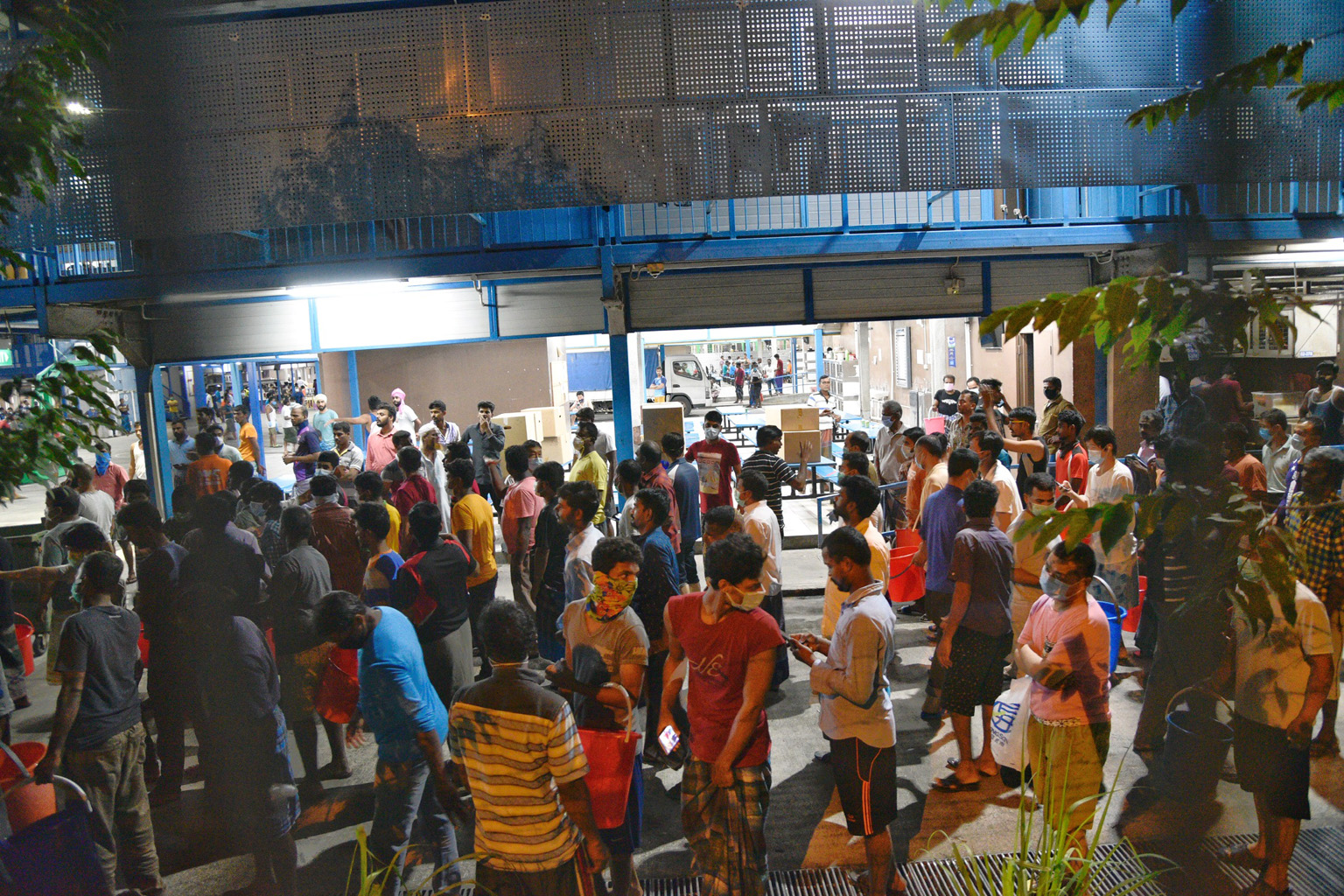 Above: Migrant workers returning yesterday to the Westlite Toh Guan dormitory. Some 6,800 of them have been told to stay in their rooms for 14 days. ST PHOTO: JASON QUAH Left: Workers at the S11 Dormitory @ Punggol yesterday. It has 63 virus cases. W