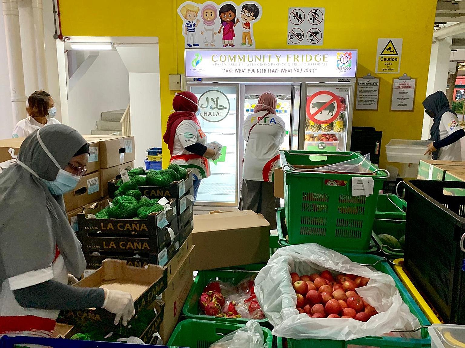 Free Food For All staff and volunteers sorting through food for one of their home deliveries to families in Yishun yesterday evening. The organisation has been distributing meals and groceries to the elderly and low-income residents living in rental
