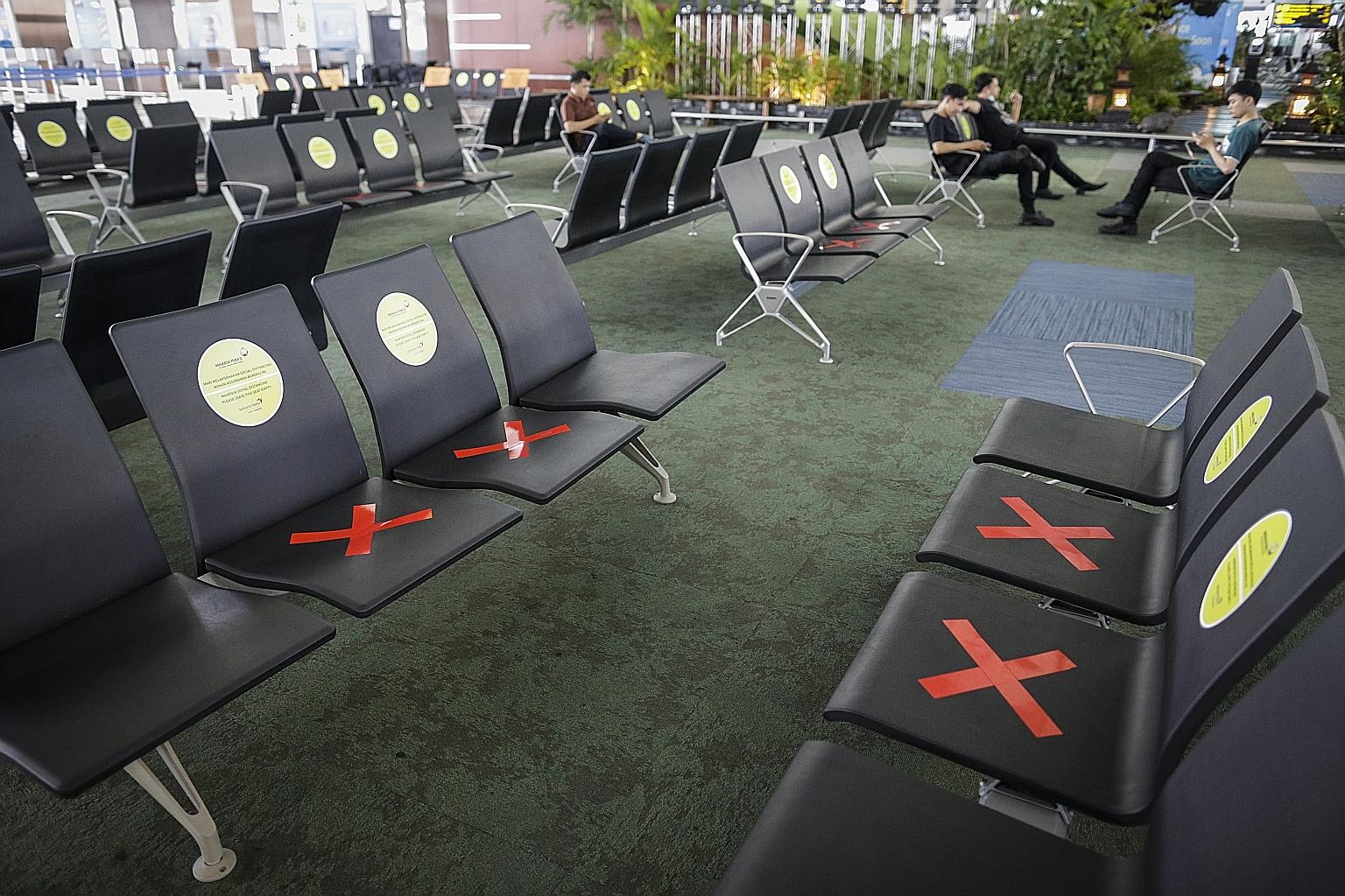 Benches are marked to remind people to practise social distancing to stop the spread of the coronavirus, at the check-in lounge of an almost-empty Soekarno-Hatta International Airport in Tangerang, Indonesia, on Tuesday. PHOTO: EPA-EFE