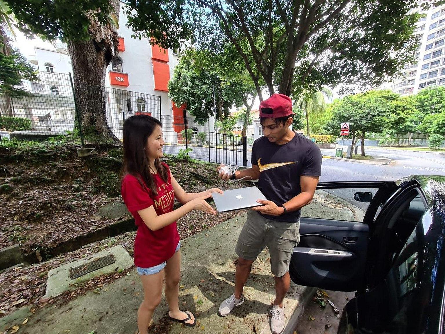Former national sprinter U.K. Shyam receiving a laptop donated by National University of Singapore medical student Caitlin Wee Fern as part of an initiative to collect devices for less privileged students.