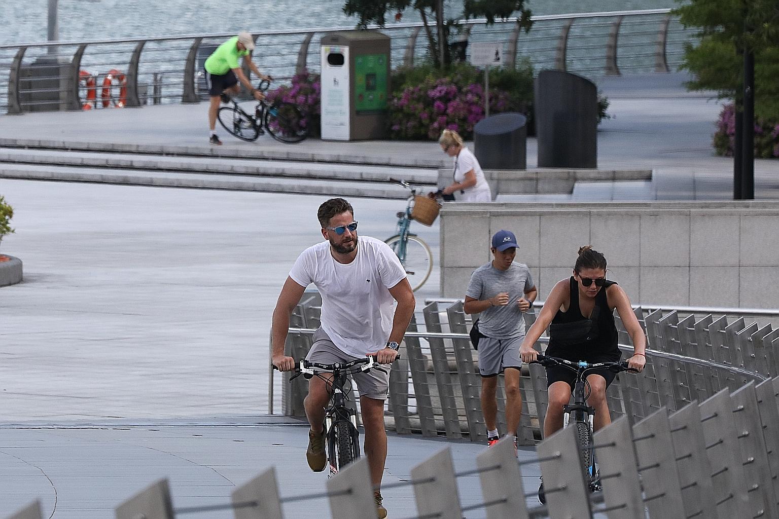 A jogger and cyclists on Jubilee Bridge on Wednesday. Researchers have found that those who walked or ran closely behind each other, and ended up in each other's slipstream, were at greatest risk of contamination. ST PHOTO: ONG WEE JIN