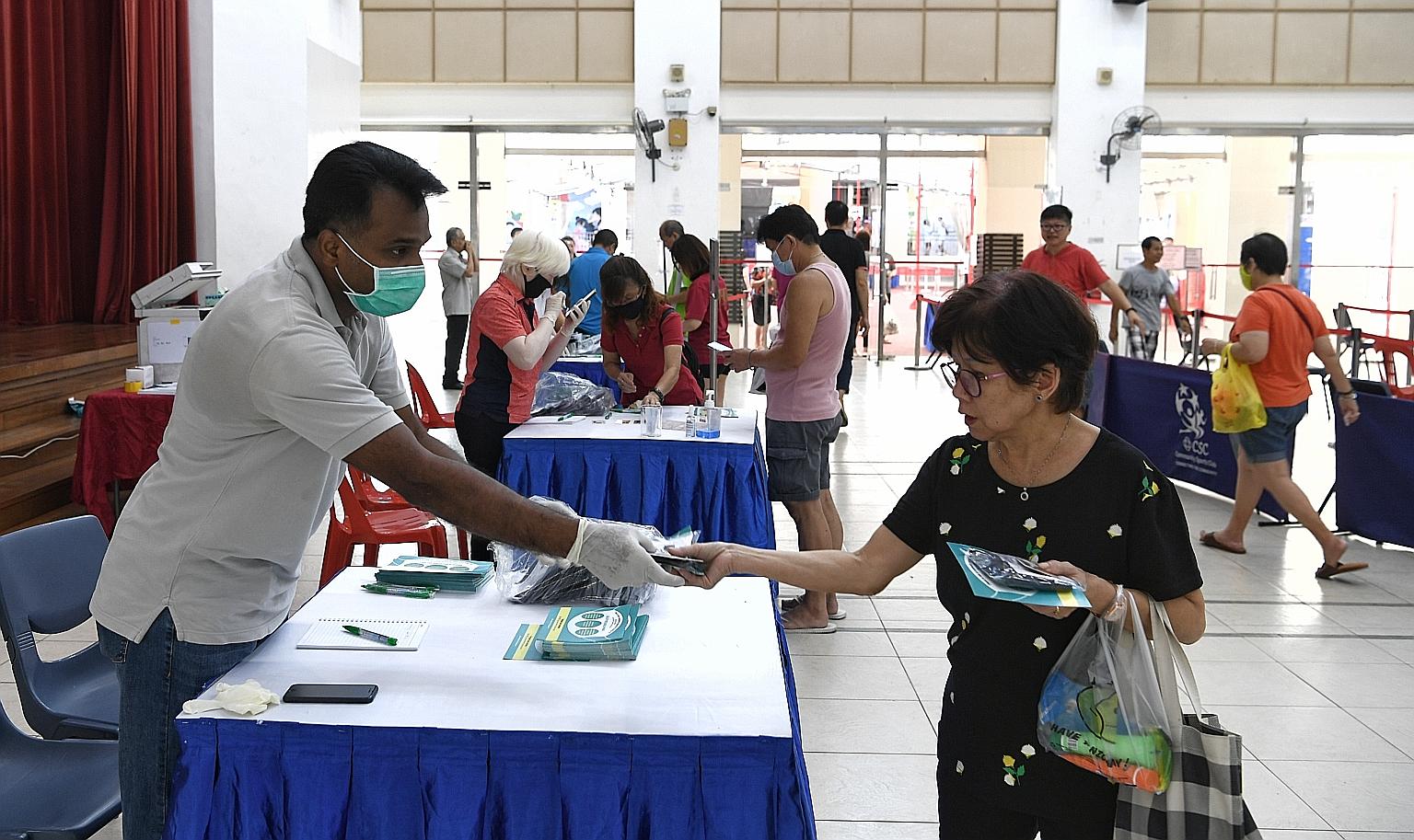 A resident collecting reusable masks for her household at Nee Soon South Community Club on Sunday. Over 3.52 million reusable masks have been collected by the public as of 6pm on Thursday. ST PHOTO: KHALID BABA