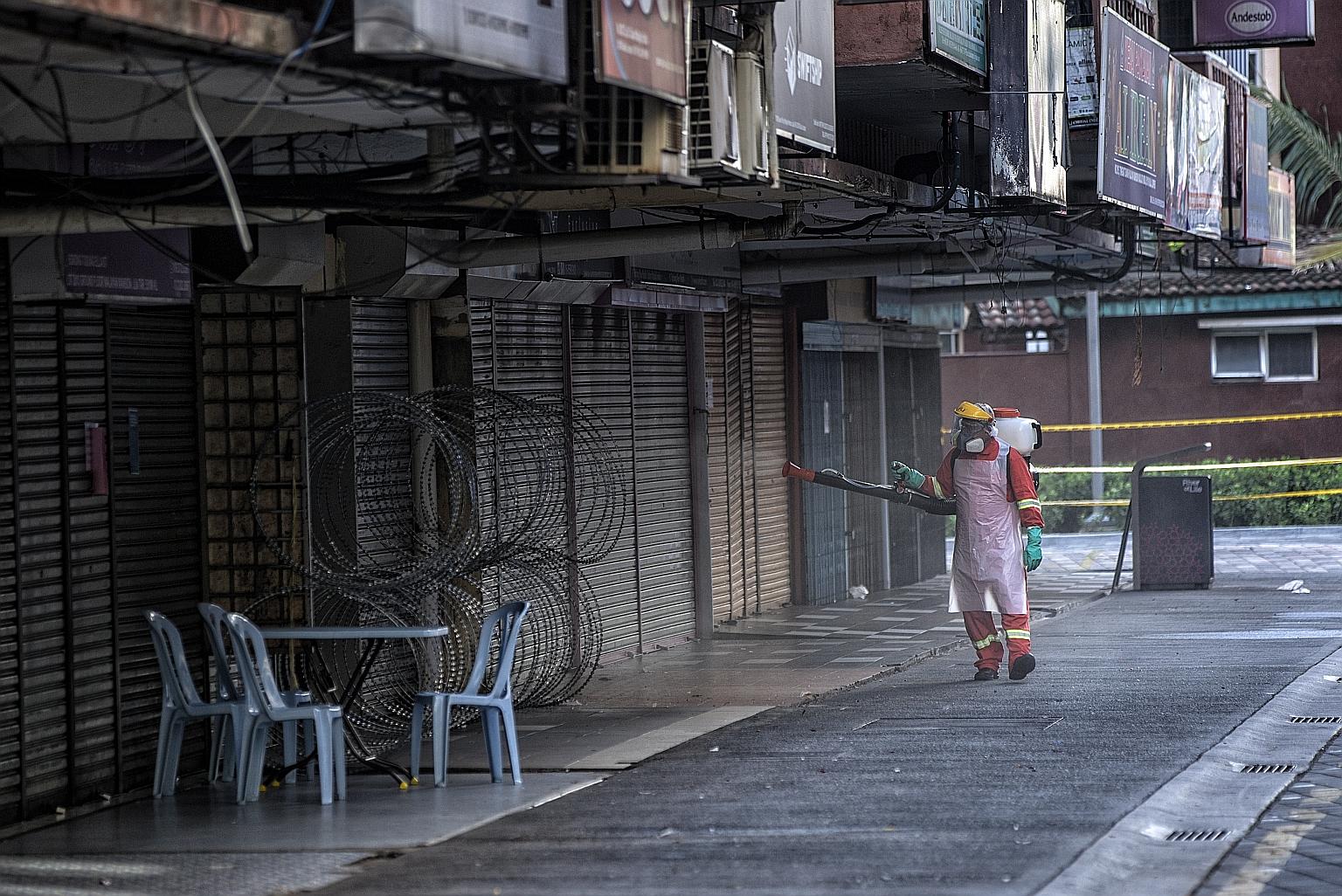 A food delivery rider in Jakarta yesterday. Indonesia's partial lockdown reflects the competing priorities between its central and local governments. A deserted street in Makati, south of Manila, last week. The Philippines has put a third of its coun