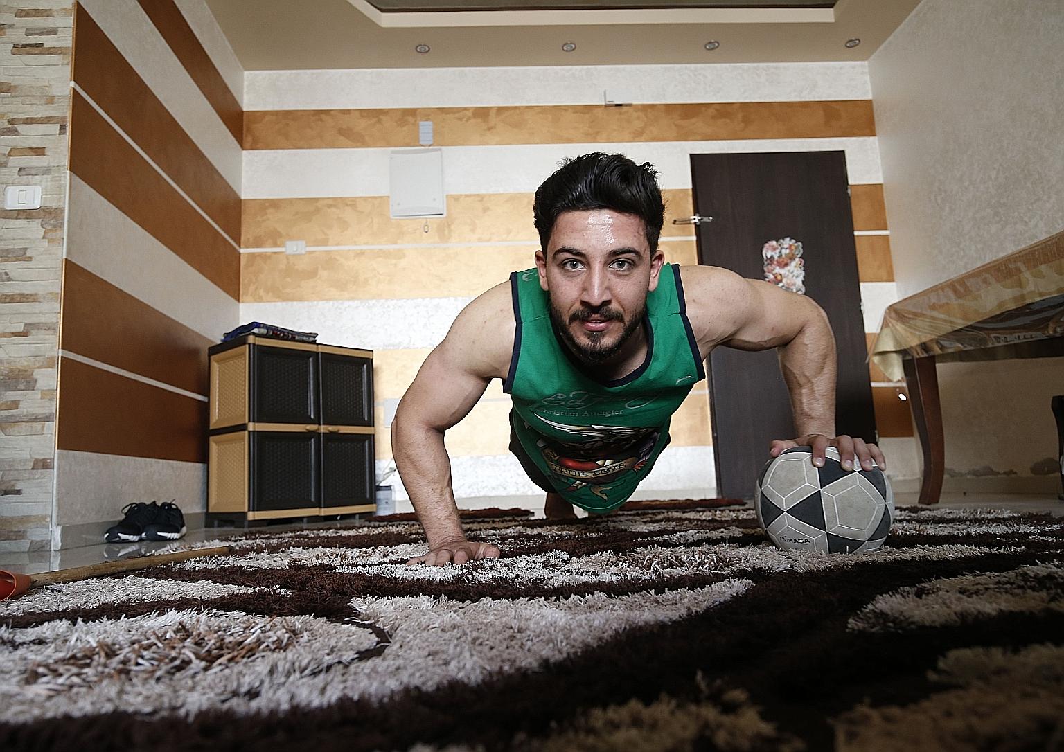 Ahmed Sawi, a Palestinian fitness and bodybuilding trainer, uses alternative tools during a training session at his home in Gaza City. PHOTO: AGENCE FRANCE-PRESSE