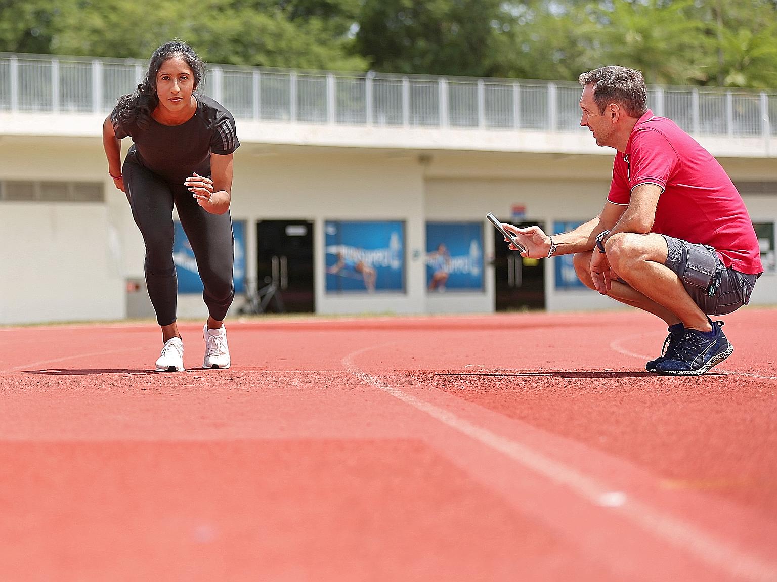 Shanti Pereira's new coach Luis Cunha guiding her through a recovery session at the Kallang track last month. Now she can still do drills and sprint on different surfaces, unlike others who need specialised equipment. ST PHOTO: JOEL CHAN