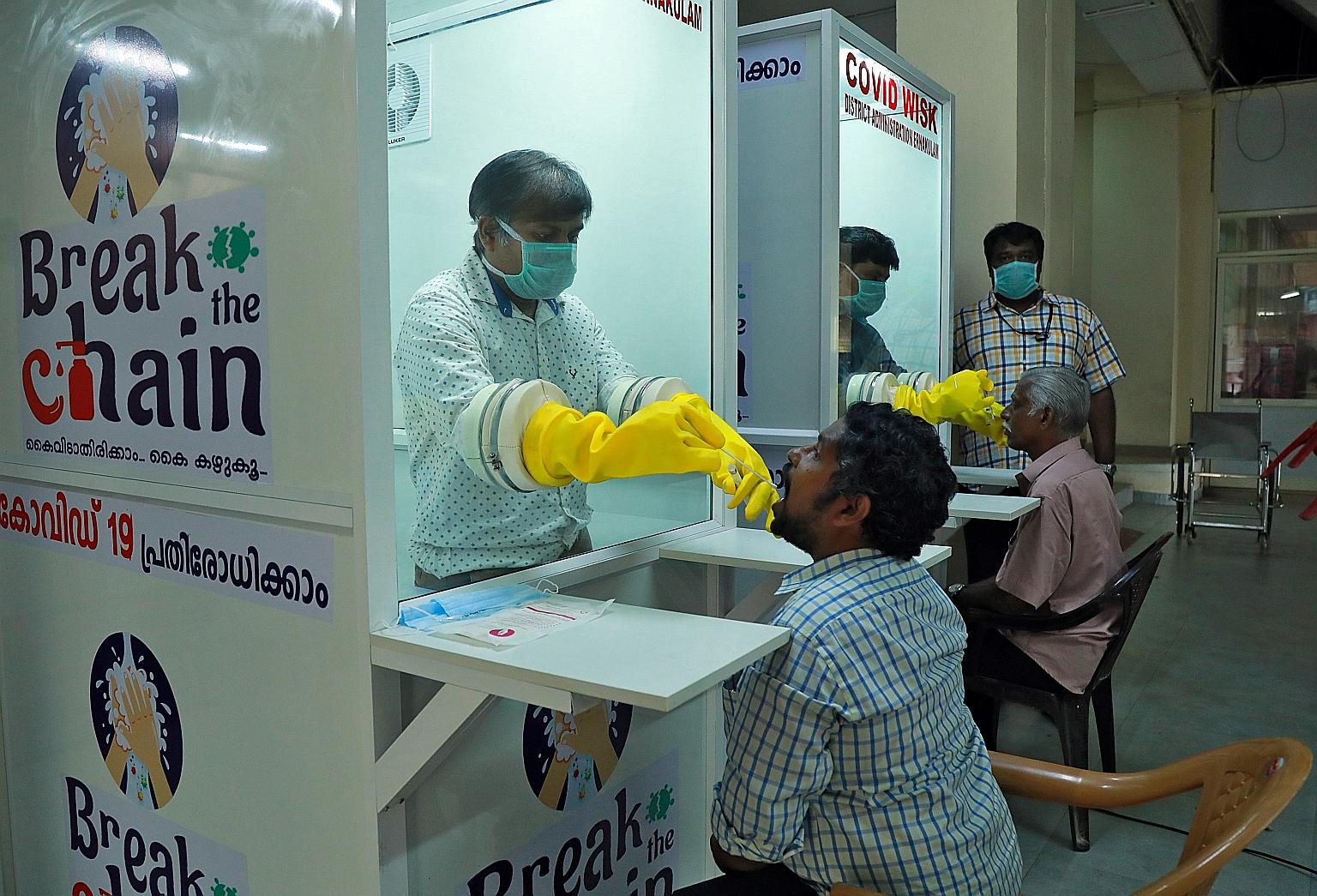 Staff from a medical college collecting swabs from people last week to test for the coronavirus at a walk-in sample kiosk in India's southern state of Kerala. Healthcare workers, who are on the front lines of the fight against Covid-19, increasingly 
