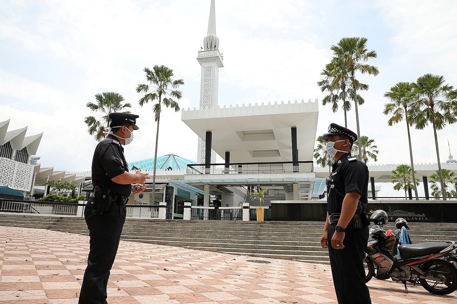 Police officers with protective masks outside the National Mosque in Kuala Lumpur last month. Malaysia said last Friday that it would extend its movement control order to April 28. PHOTO: REUTERS Devotees adhering to social distancing measures during