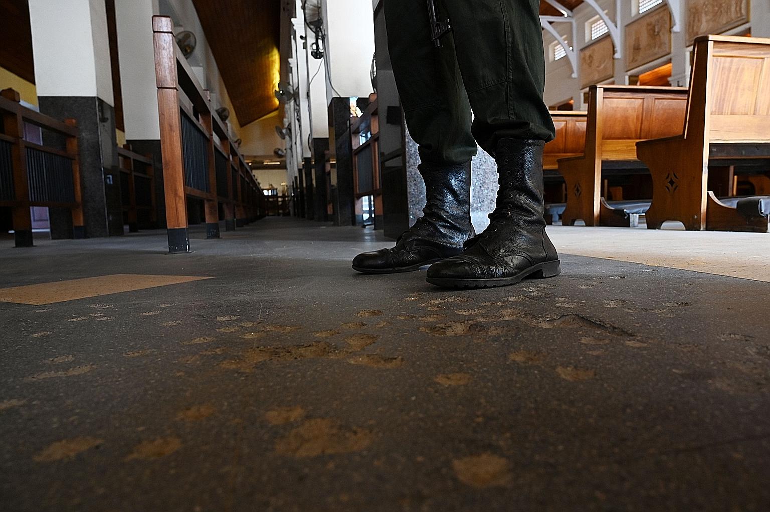 A soldier standing guard inside St Anthony's Church (above) in Colombo yesterday on the first anniversary of the Easter Sunday bombings. The bombers targeted three churches and three luxury hotels, killing at least 279 people and wounding 593. A file