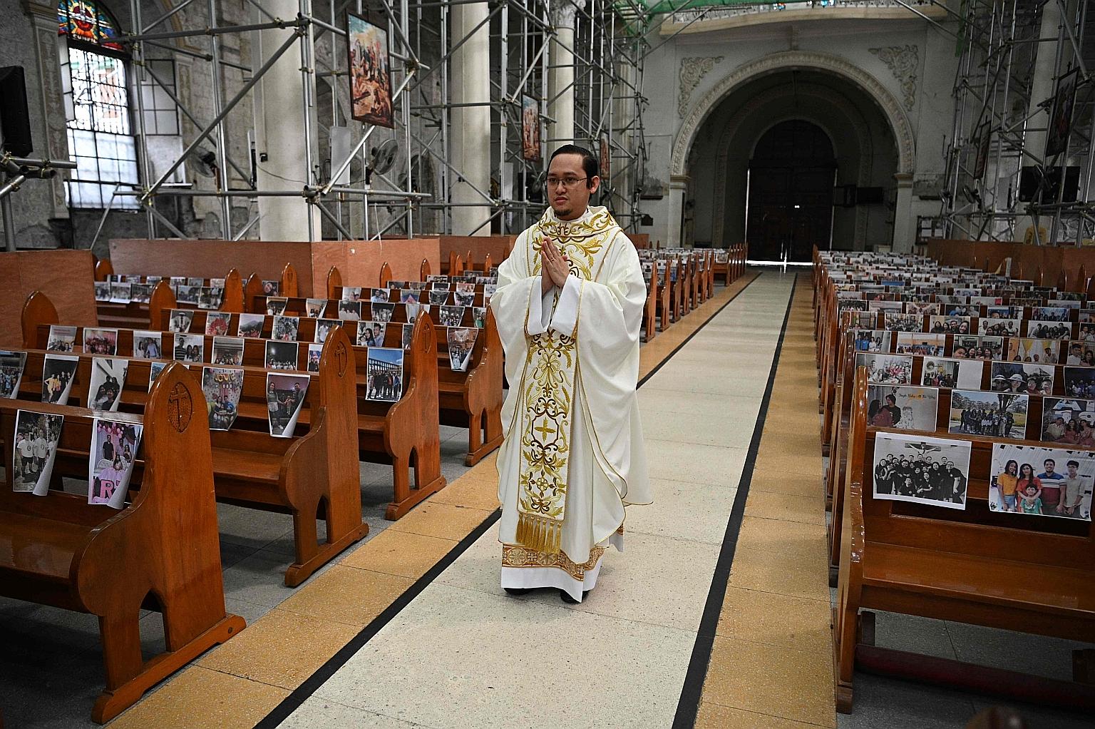 Reverend Father Mark de Leon walking down the aisle in an empty Holy Rosary Parish Church at the start of a procession for Easter Mass in Angeles City in the Philippines' Pampanga province yesterday. In place of parishioners who were not present due