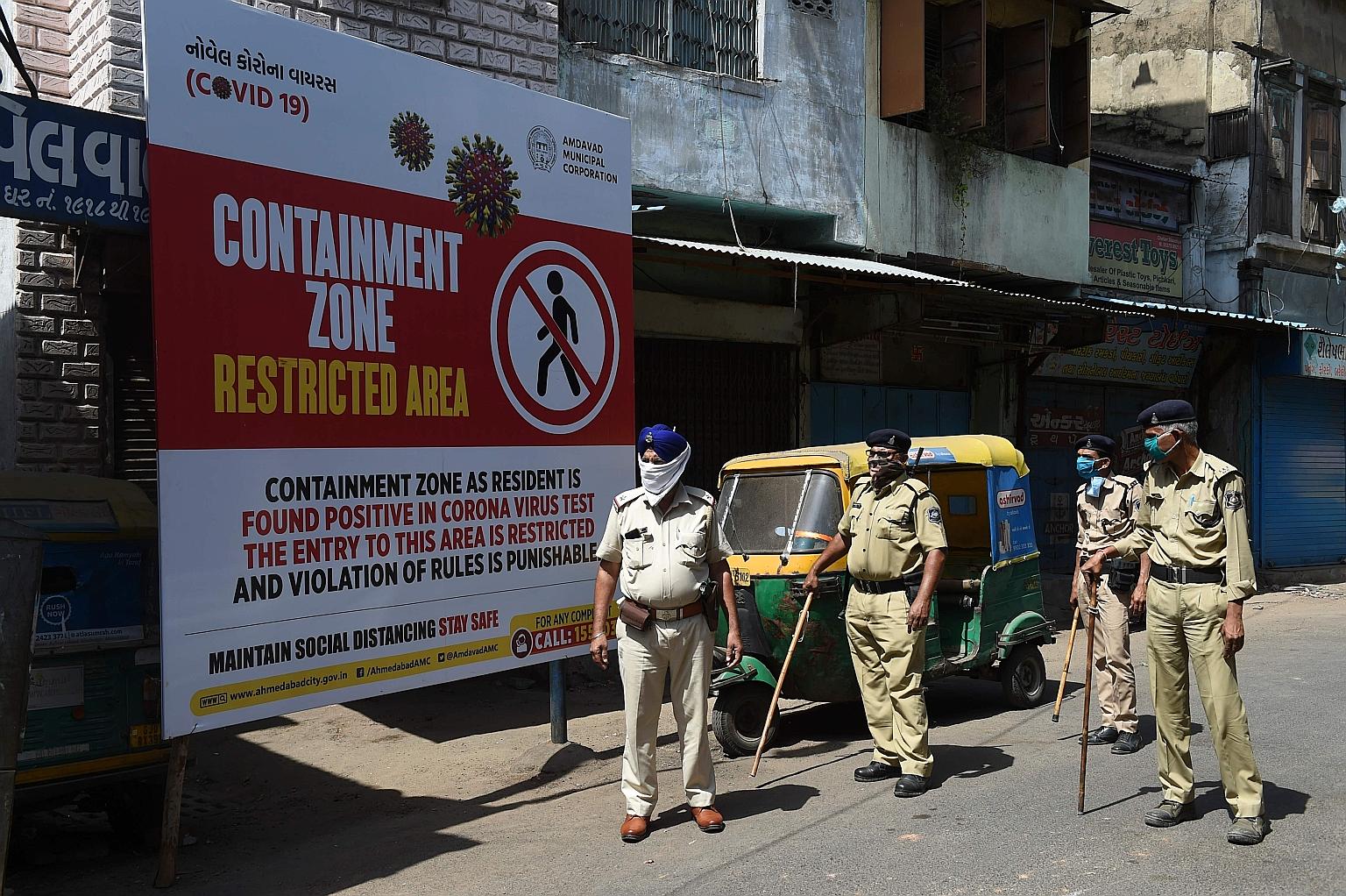 Policemen with face masks in a coronavirus containment zone in Ahmedabad, Gujarat state, last week. India's lockdown, which was due to end tomorrow, looks set to be extended by two more weeks till the end of this month. PHOTO: AGENCE FRANCE-PRESSE