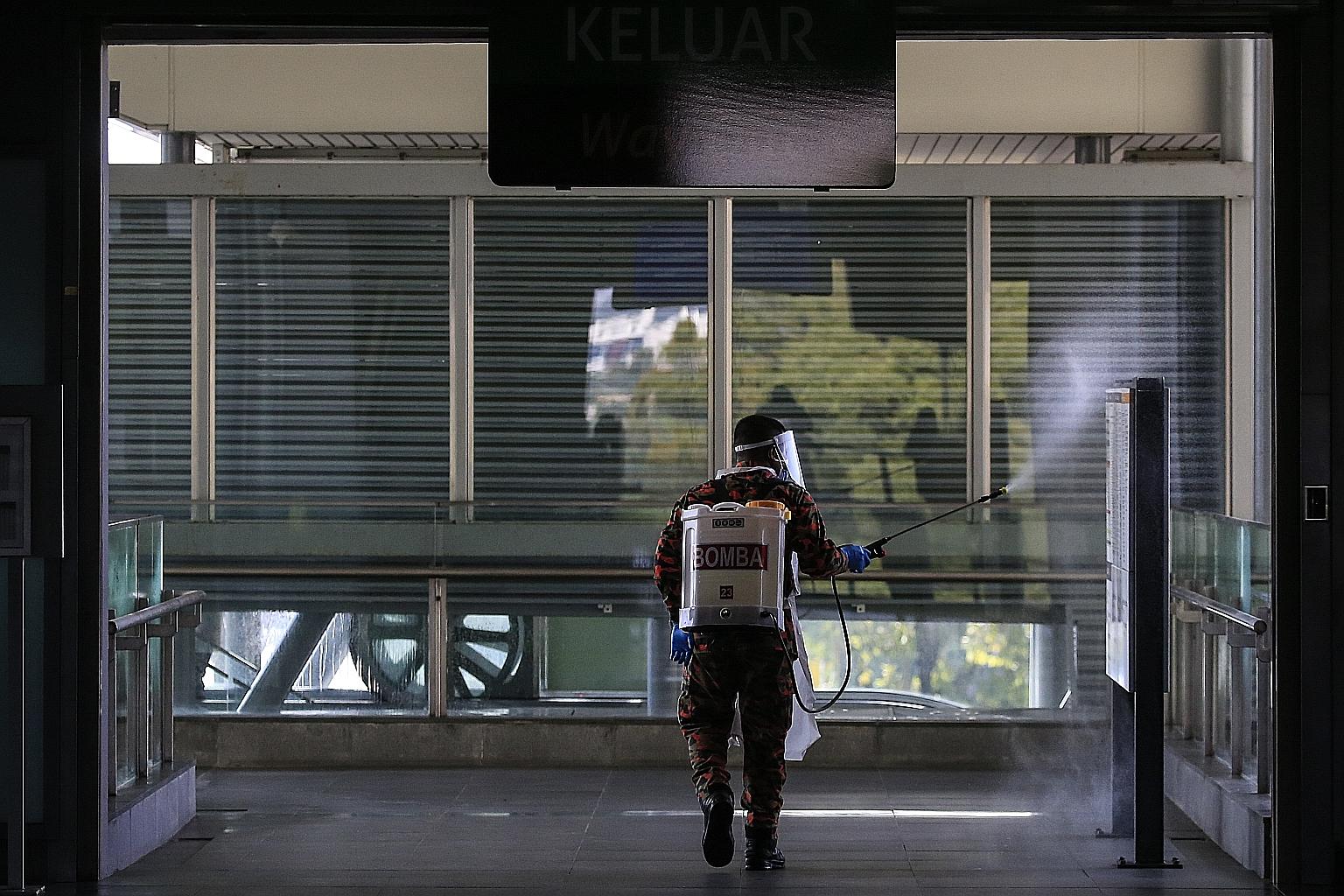 A Malaysian Fire and Rescue Department worker disinfecting the subway train station in Kajang, outside Kuala Lumpur, last week. Malaysia's movement control order has led to the closure of schools and non-essential businesses, largely confined people 