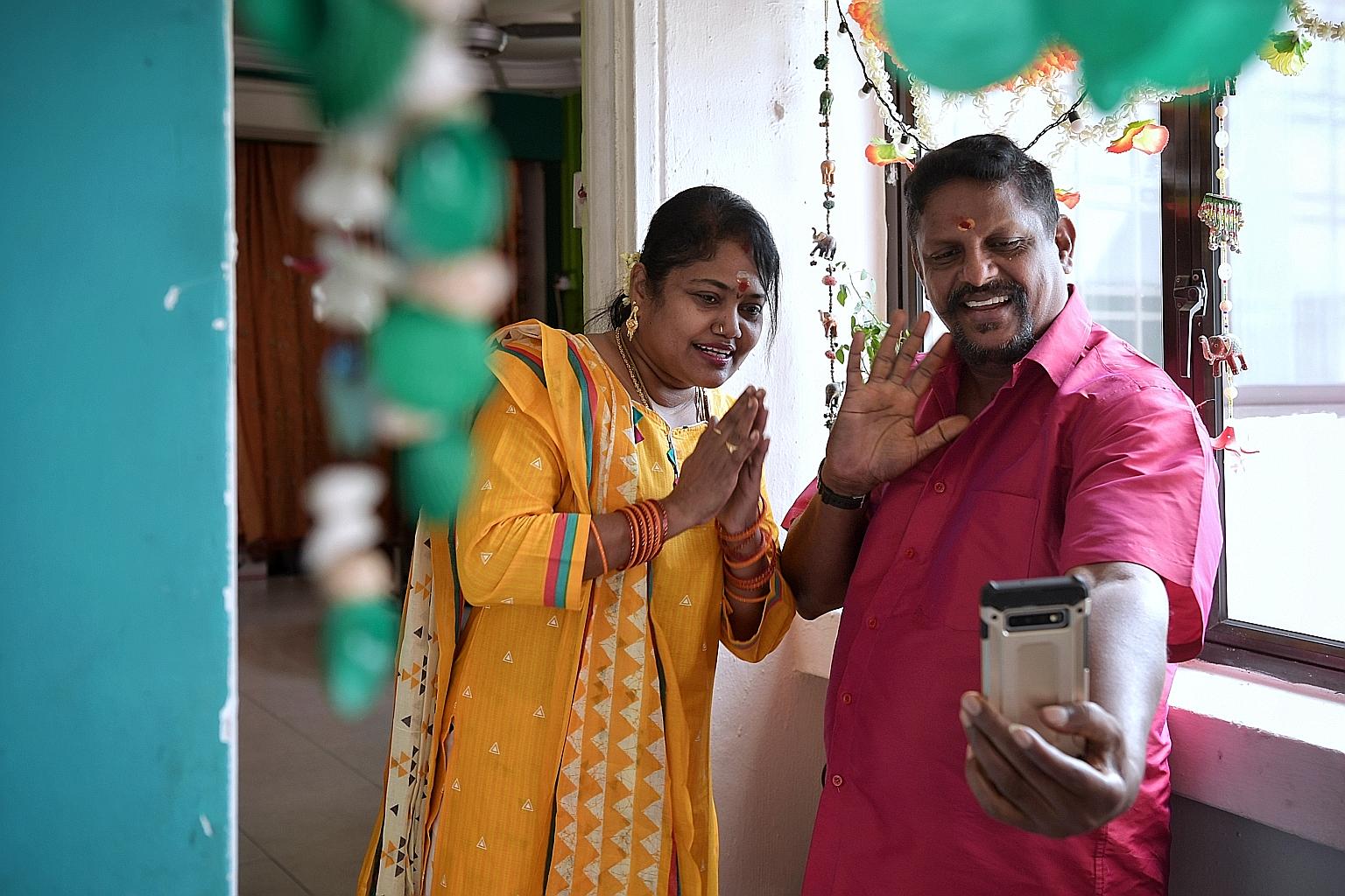 Ms Punkothai Mukan, 52, and her husband Gunalan Veerasamy, 56, celebrating the Tamil New Year at home yesterday. Mr Gunalan, who is unable to visit his mother and relatives in Malaysia this year, greeted them via video call. ST PHOTO: KUA CHEE SIONG