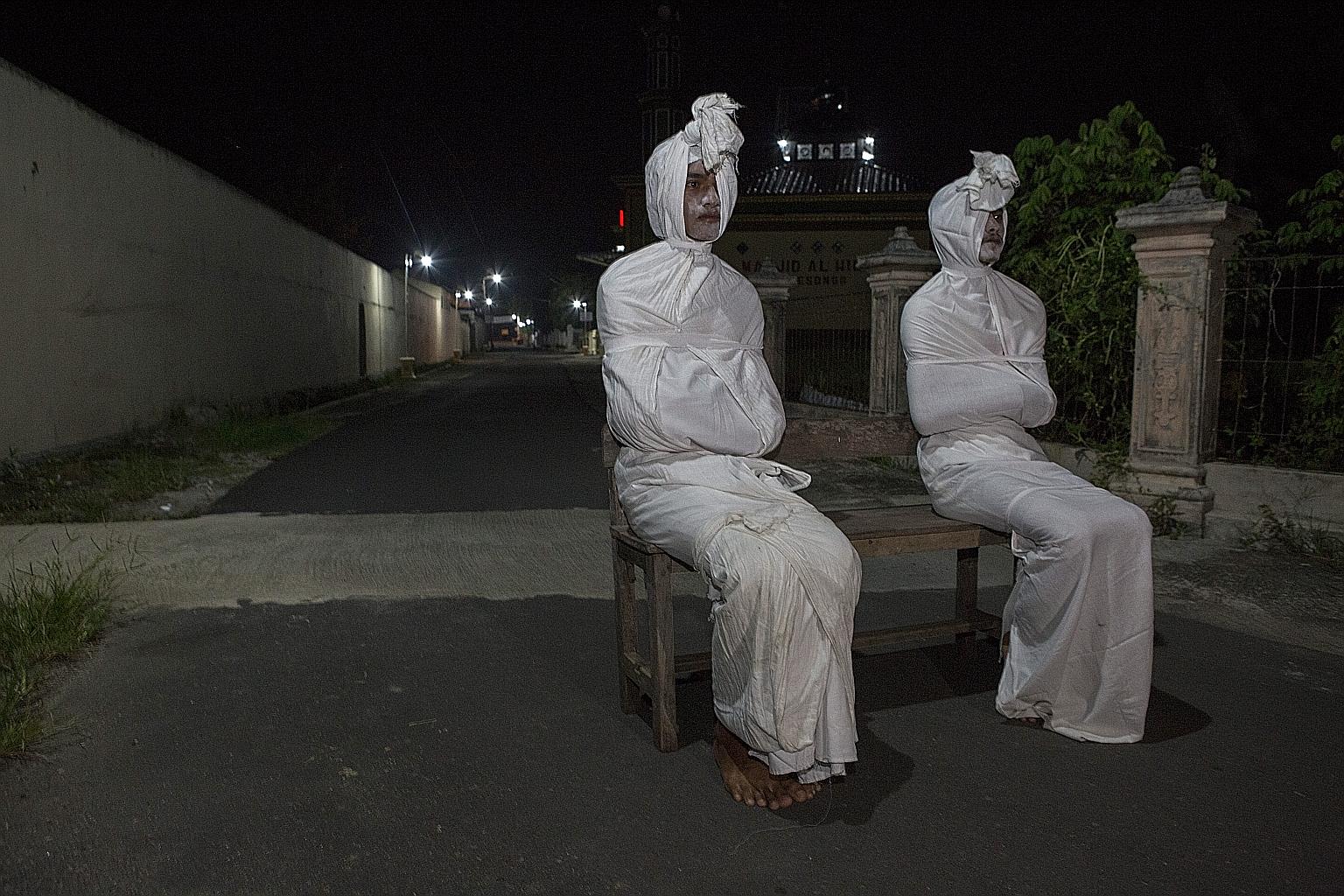 Volunteers dressed as "pocong", or shroud ghosts, in a bid to urge people to stay home amid the coronavirus outbreak in a village in Sukoharjo, Central Java. Indonesia yesterday reported 27 more deaths from the virus, which has now claimed close to 5