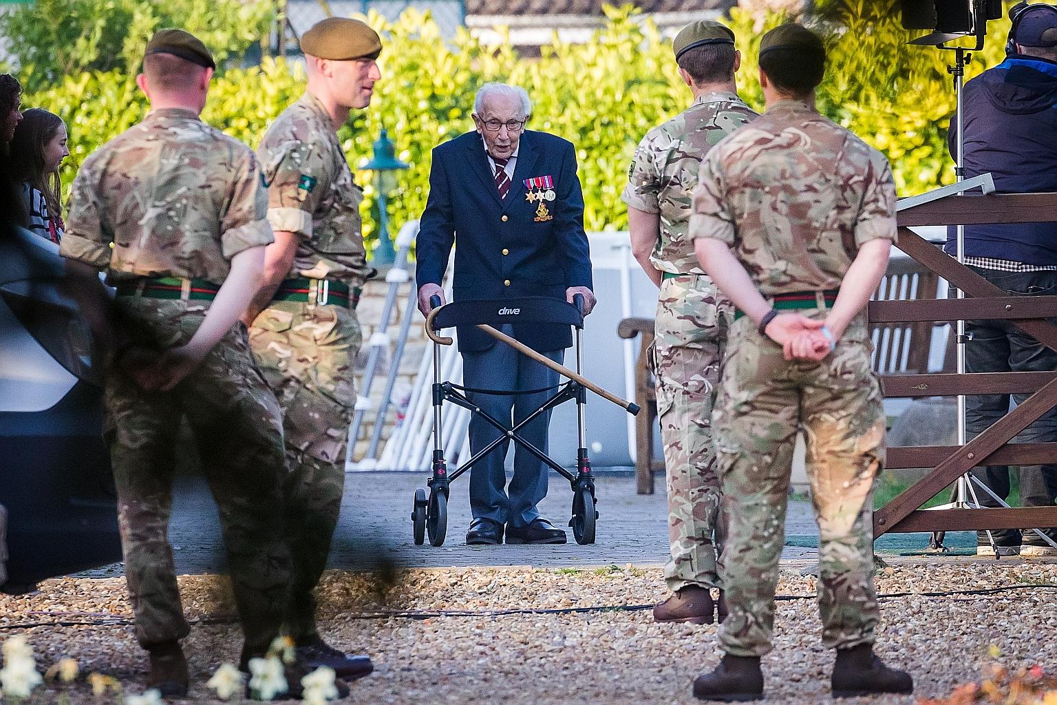 Mr Tom Moore, an army captain who served in India, completing the 100th lap of his 25m garden in England yesterday. The final lap was met with a guard of honour from the Yorkshire Regiment and broadcast live on British TV.