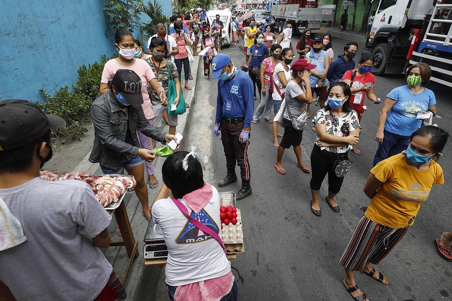 People claiming food coupons as part of a government programme to help those affected by the lockdown in Pasig city, Metro Manila, yesterday.