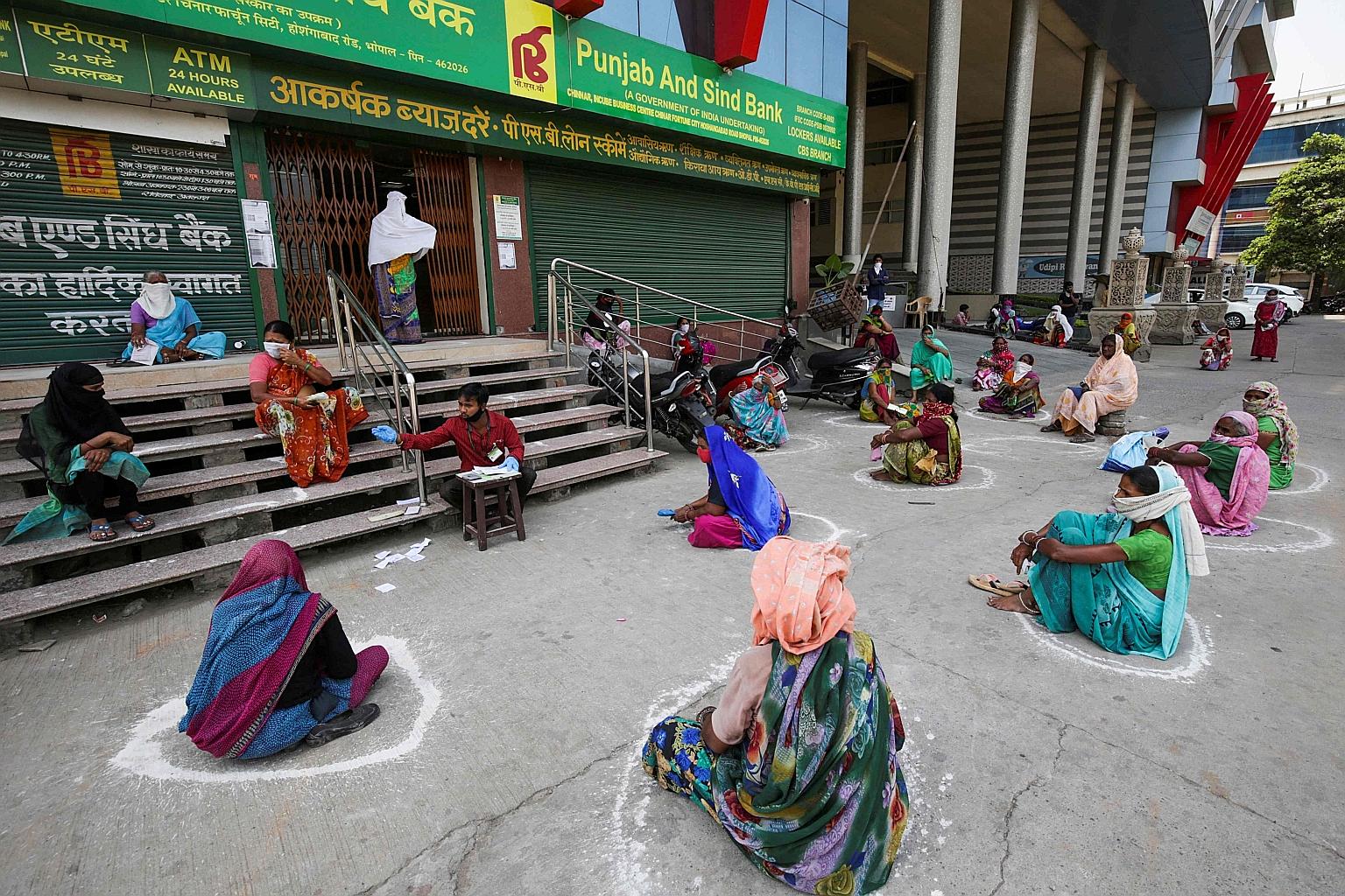Women practising social distancing outside a bank while waiting to collect their pension during a nationwide lockdown amid the pandemic, in Bhopal, India, on Wednesday. PHOTO: AGENCE FRANCE-PRESSE
