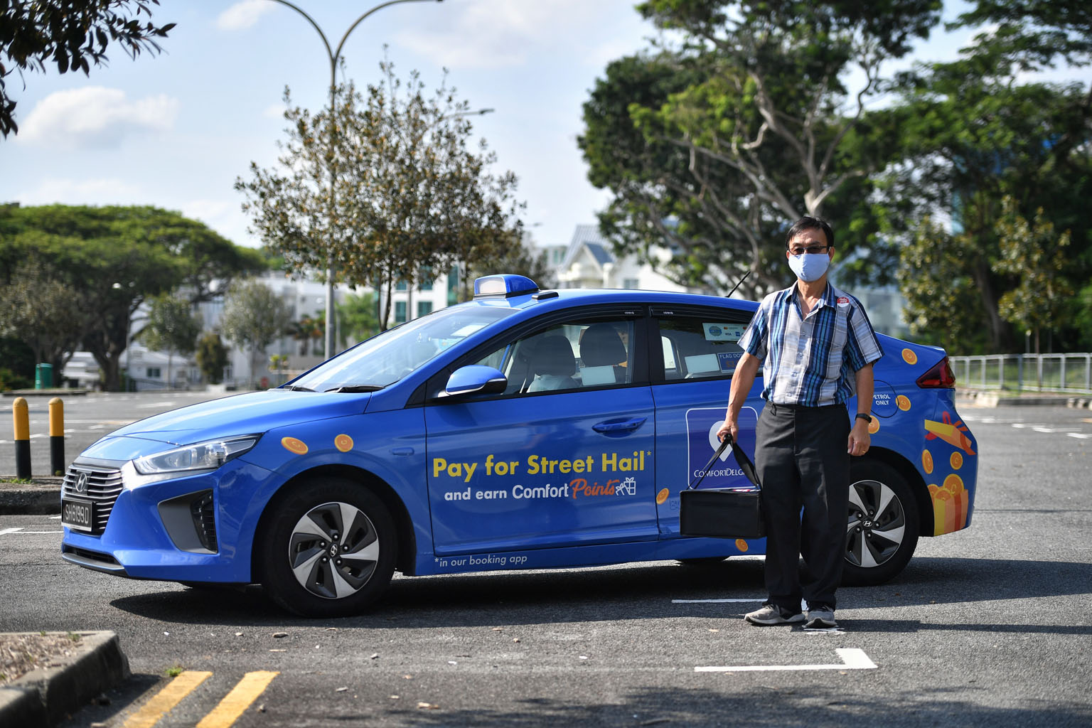 Cabby Toh Kian Seng, 57, with a KFC delivery order yesterday. The experience of delivering food orders is new to him, but he said it is better than plying streets bereft of passengers, given the circuit breaker measures. ComfortDelGro has close to 11