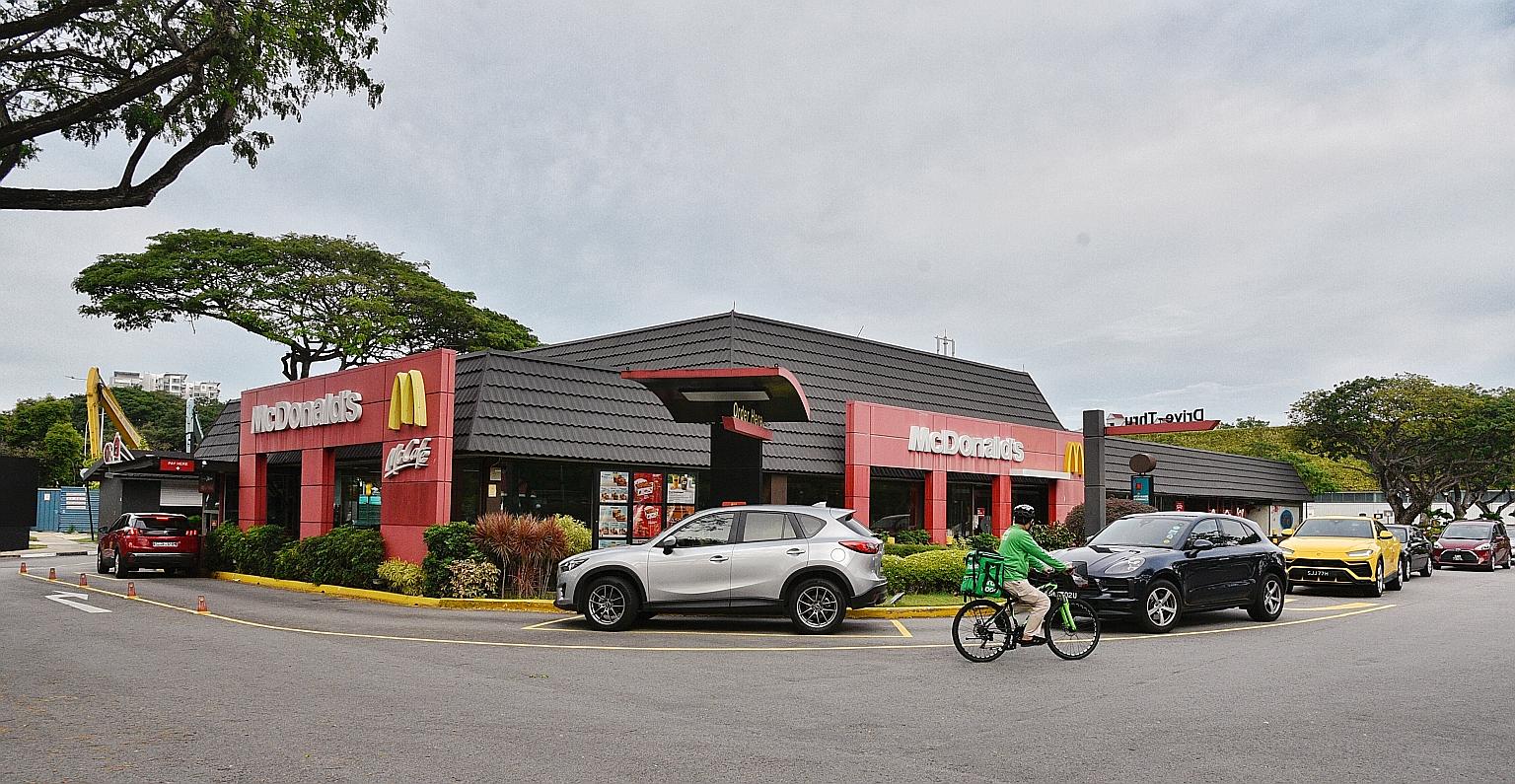A line of cars forming outside McDonald's Kallang drive-through outlet yesterday, the first day the fast-food chain stopped offering walk-in takeaways until 11.59pm on May 4. McDonald's Singapore said the precautionary move would help "flatten the cu