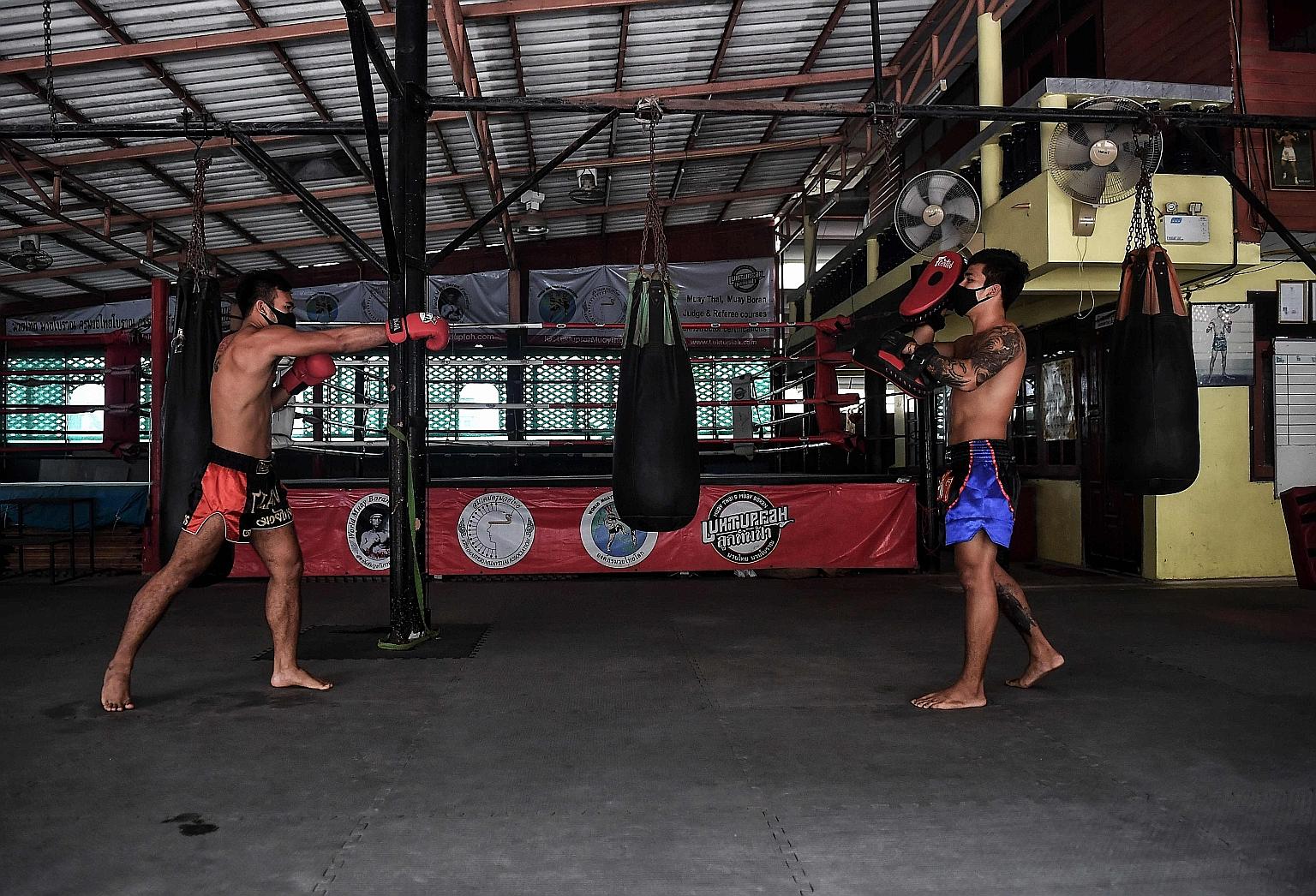 Pro fighters Pongpisarn Sunyong (left) and Sarawut Prohmsut going through their drills earlier this month, while standing 2m apart at the Luktupfah Muay Thai School in Bangkok. The last two boxers living in the gym now train in isolation.