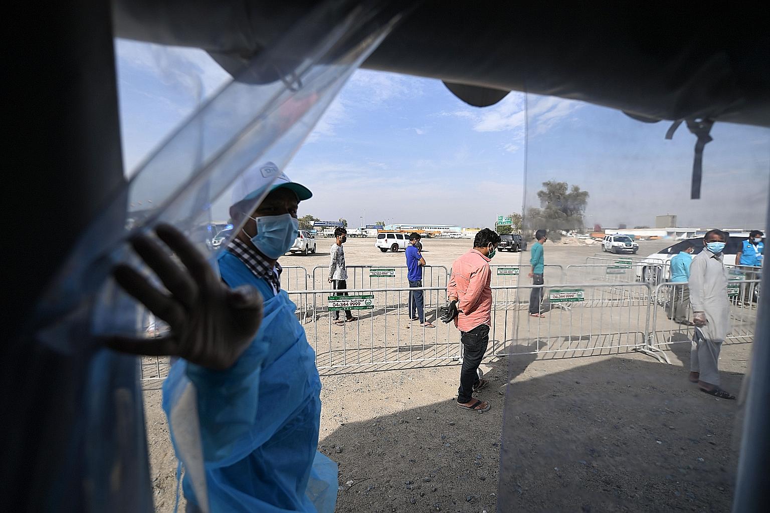 Foreign workers waiting in line to be checked for the coronavirus at a testing centre in Dubai, in the United Arab Emirates, last Saturday. PHOTO: AGENCE FRANCE-PRESSE
