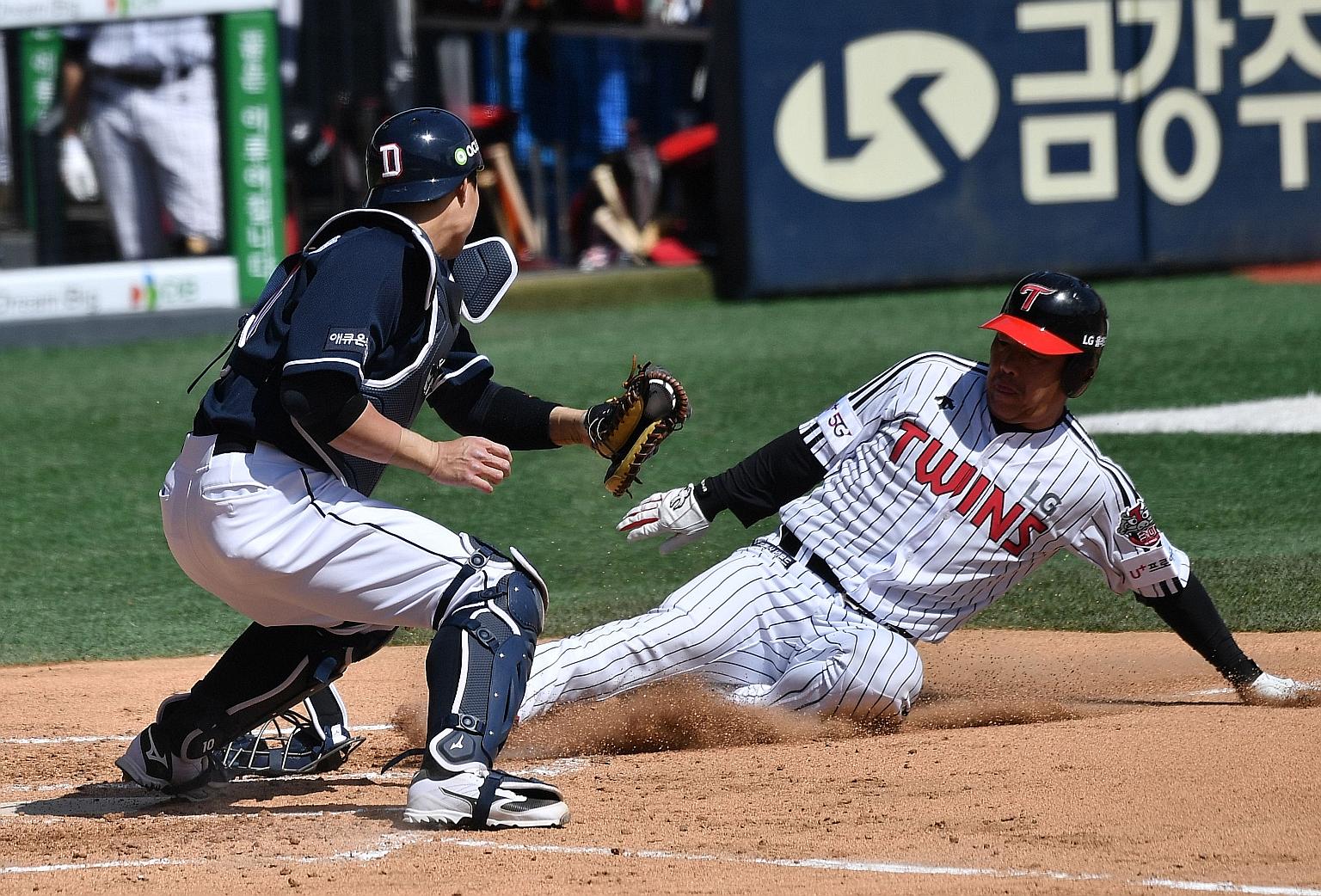 LG Twins' Jeong Keun-woo sliding at home plate, only to be tagged out by the Doosan Bears' Park Sei-hyok during a pre-season baseball game between the two Seoul-based teams at the Jamsil Olympic Stadium in the South Korean capital yesterday. Professi