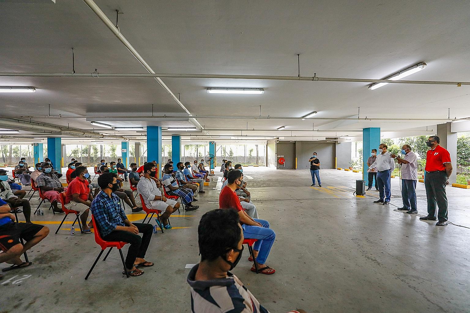Minister for Home Affairs and Law K. Shanmugam (centre) speaking to workers at the Westlite Papan dormitory yesterday, flanked by Summit Group founder and chairman Muhammed Aziz Khan and Nominated MP Arasu Duraisamy (right).