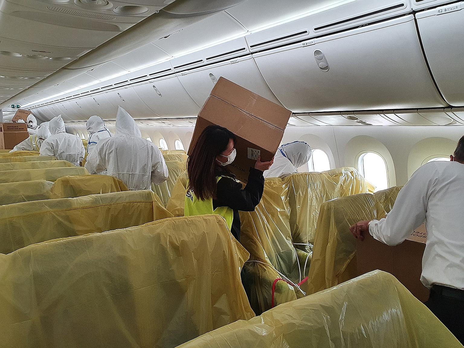 An SIA staff member with a box of medical supplies on board one of the carrier's passenger planes.