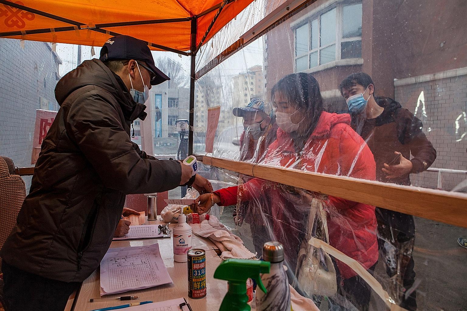 A woman having her temperature checked in the border city of Suifenhe in China's north-eastern Heilongjiang province.