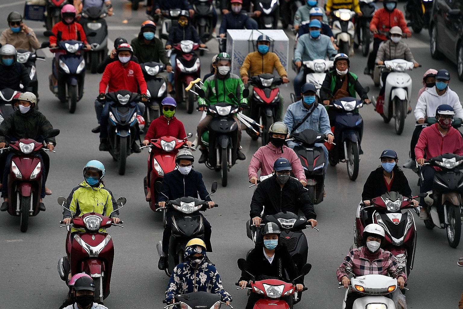Motorists in Hanoi yesterday. Vietnam has been under partial lockdown since the beginning of this month, but the government has said that some shops and services will be allowed to reopen.