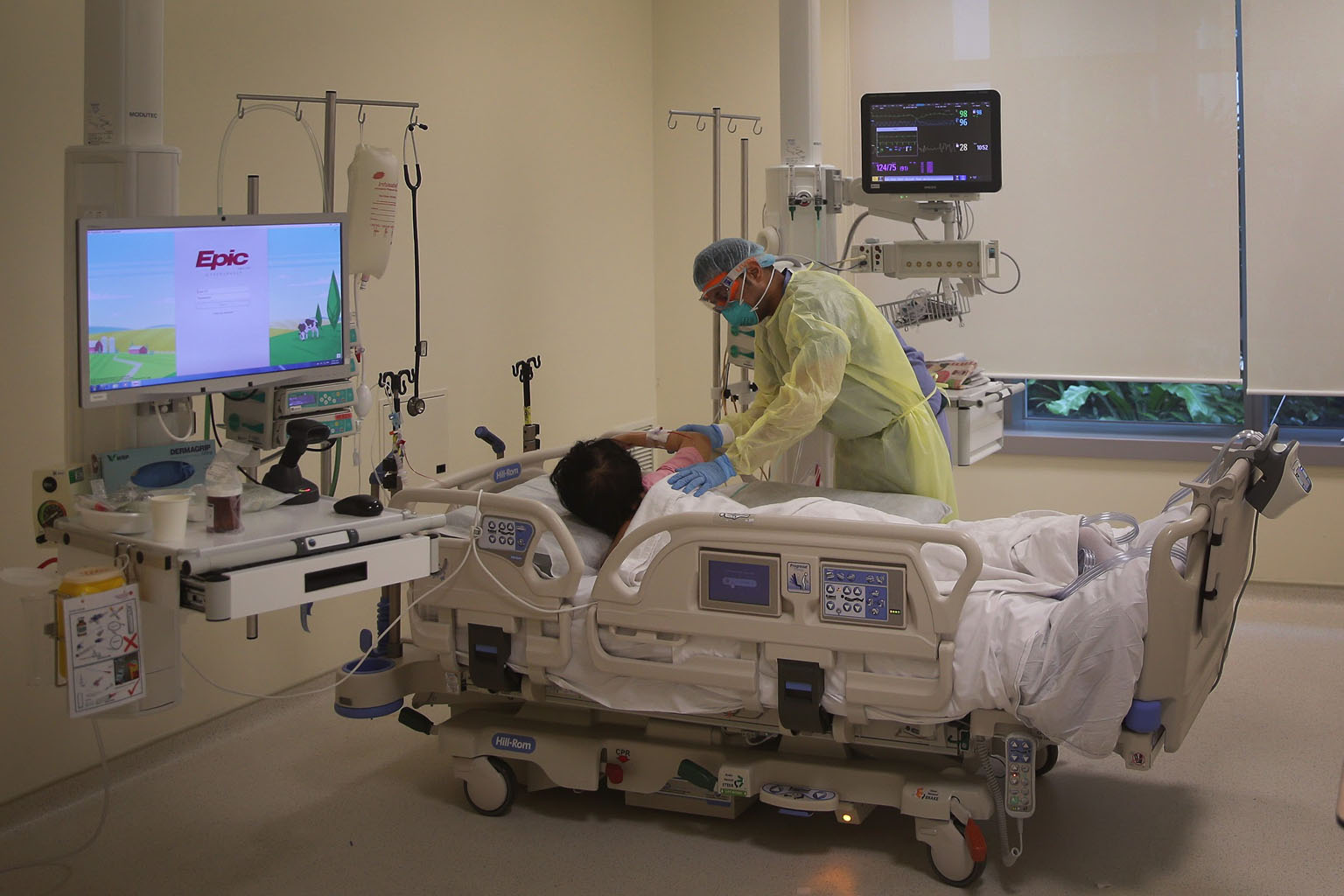 Dr Nikhil Gautam, a resident physician at Ng Teng Fong General Hospital, helping a Covid-19 patient into the prone position in the intensive care unit's isolation room on Tuesday. ST PHOTO: KEVIN LIM