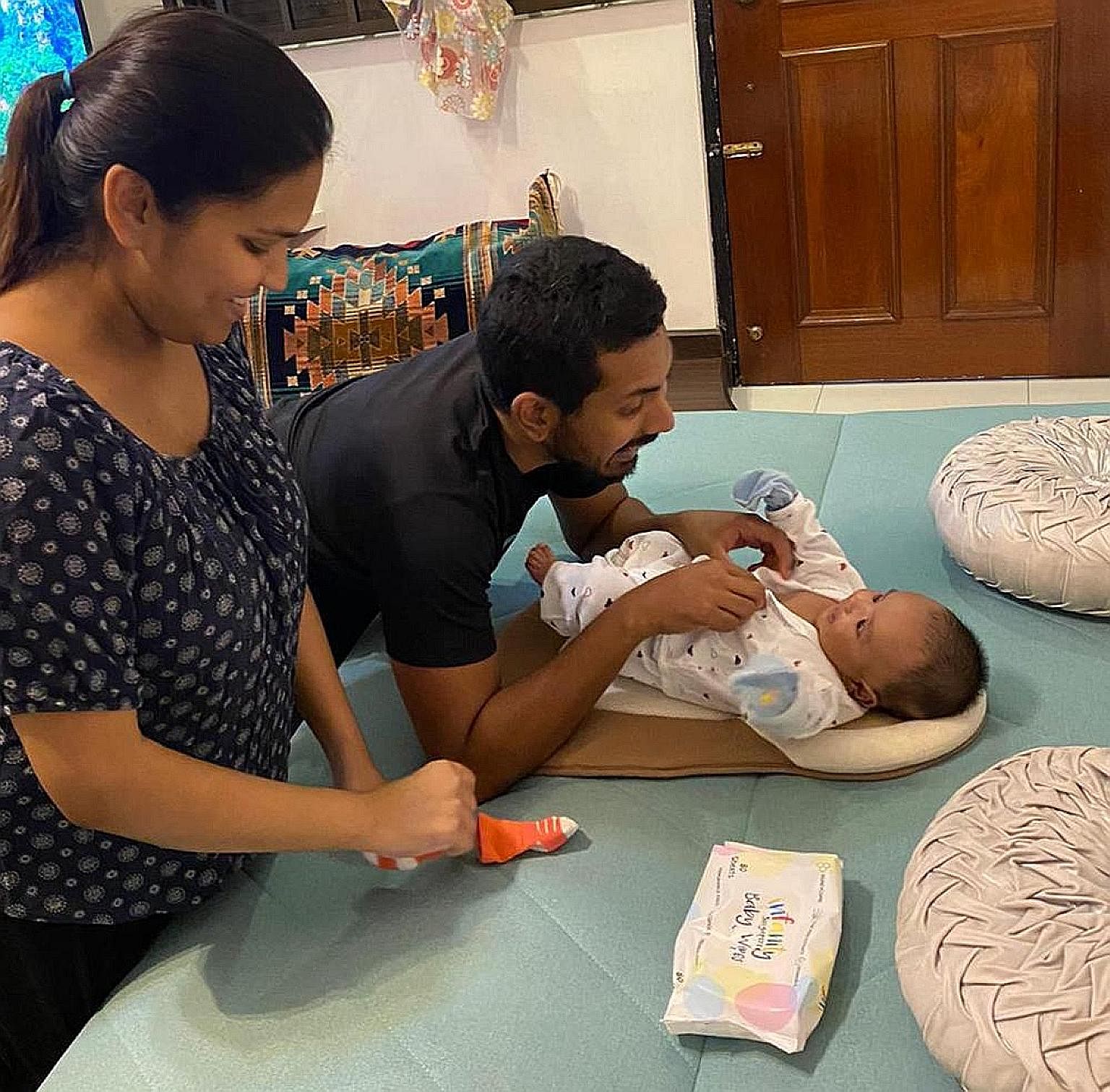 Ms Noor Syuhada Mohamad Rafeek and her husband Shukri Abdul Jalil taking care of their son. 