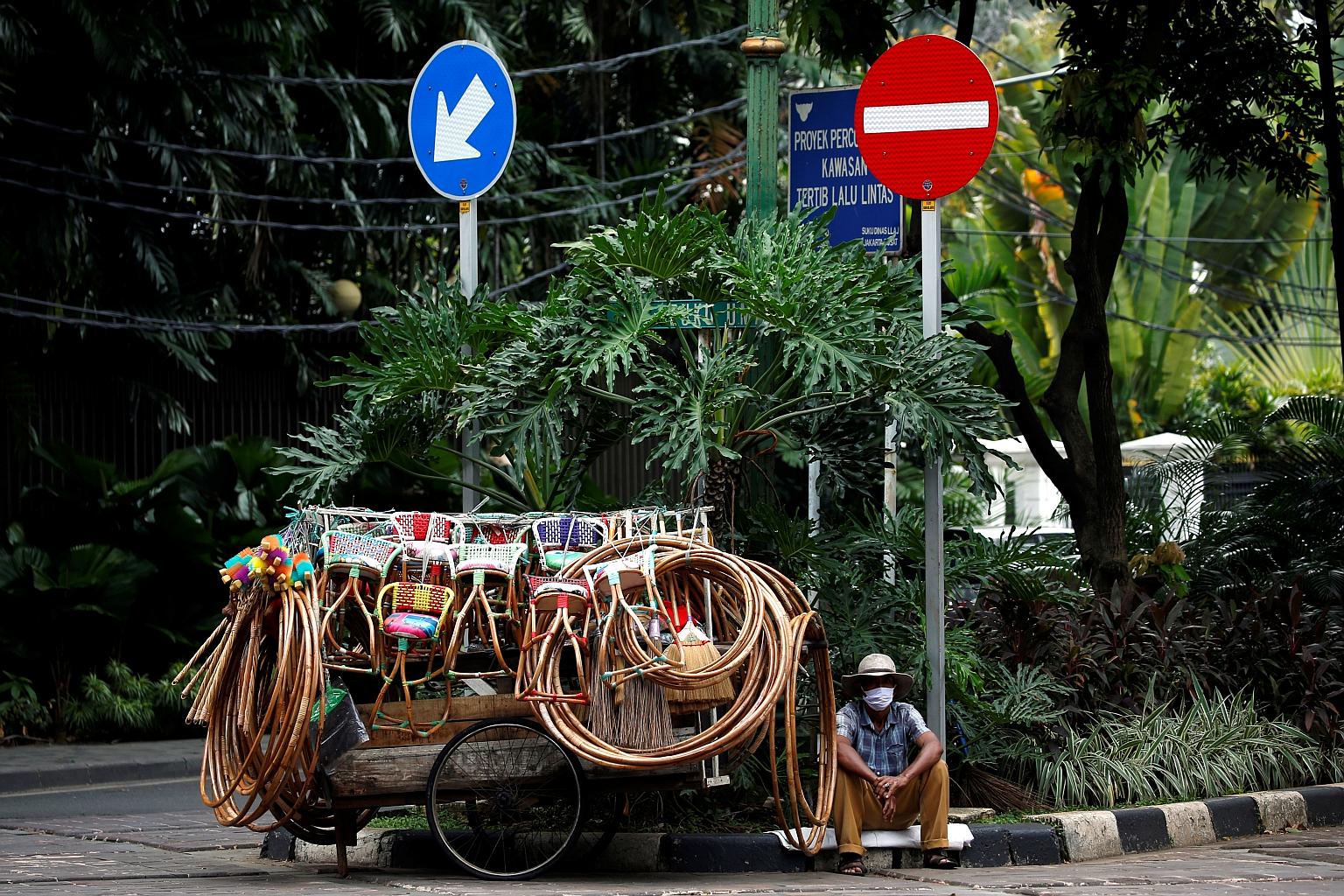 A street vendor in Jakarta yesterday. All over the Indonesian capital, businesses small and large have to find creative ways to hawk their goods to customers and stay afloat after the government said last Wednesday that it would extend its stay-at-ho