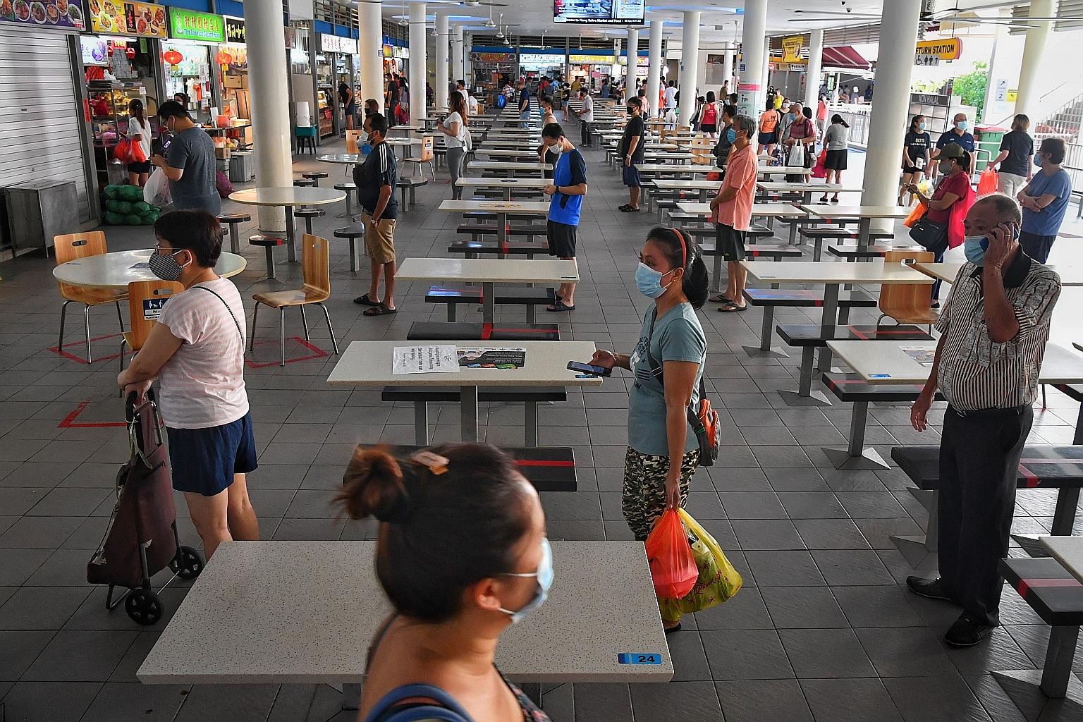 Customers observing a safe distance as they queued at the Tiong Bahru Hawker Centre yesterday. Singaporeans and permanent residents made up seven of the nine new Covid-19 cases in the community, while work pass and long-term pass holders made up the 