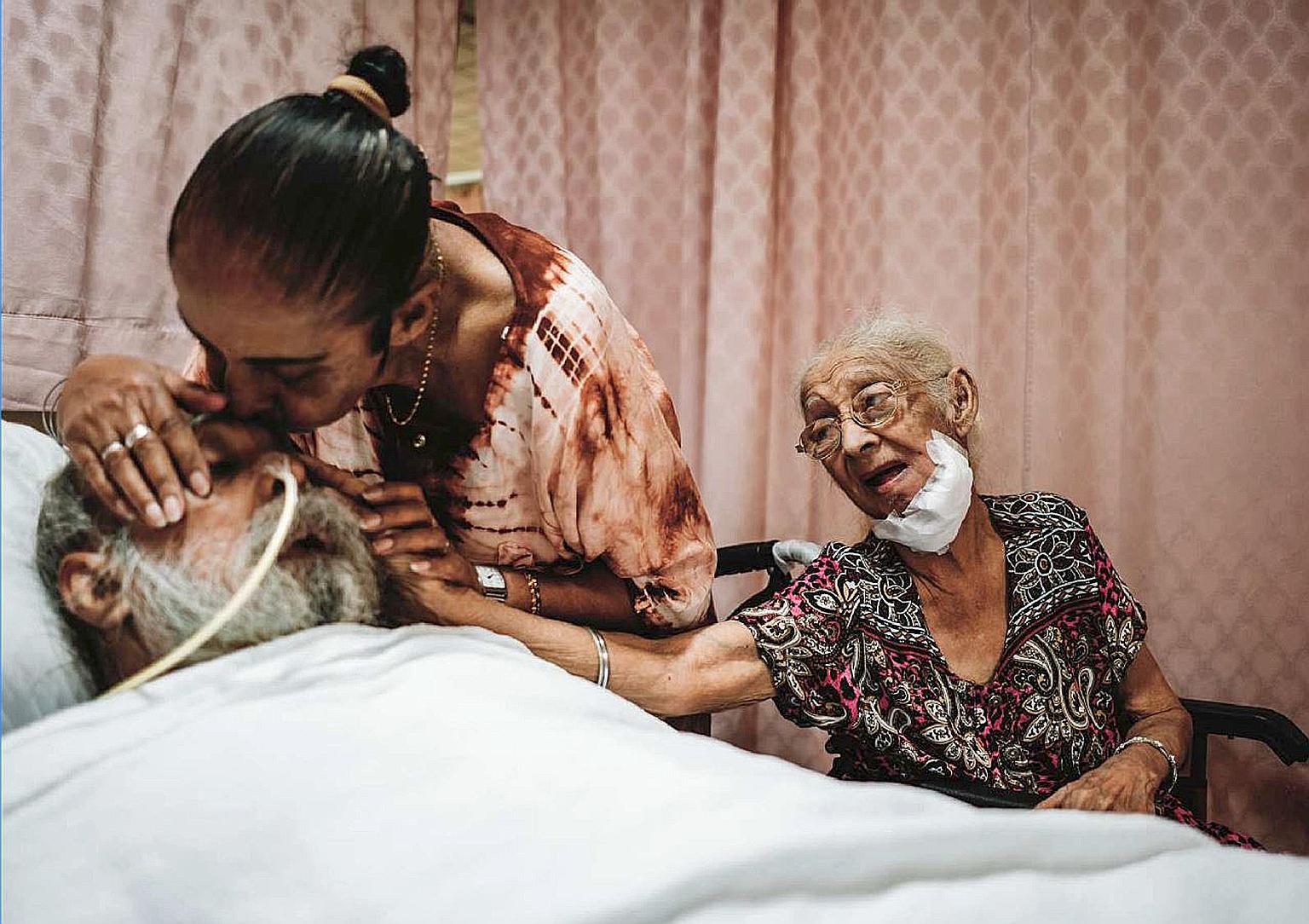 In a photo taken before the circuit breaker began, an HCA Hospice Care patient, Madam Niranjan (at right), and her daughter say goodbye to Madam Niranjan's son before his death. PHOTO: HCA HOSPICE CARE