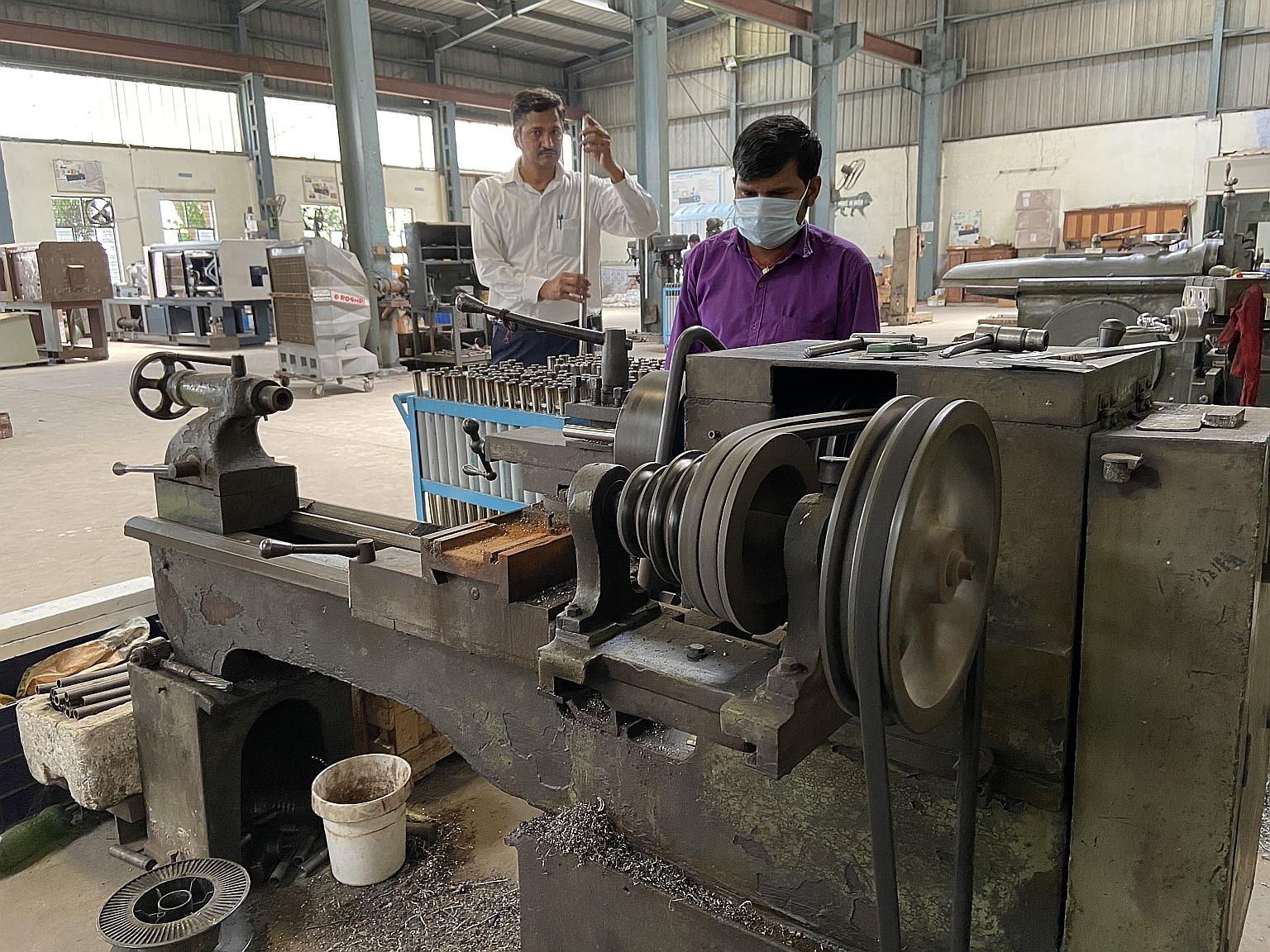 Mr Praveen Sharma, owner of Hinds Plastic Machines, inspecting an unfinished pole for intravenous drips manufactured in his Manesar factory in Haryana, India, last Friday. He has no plans to seek permission for his core business of producing machines