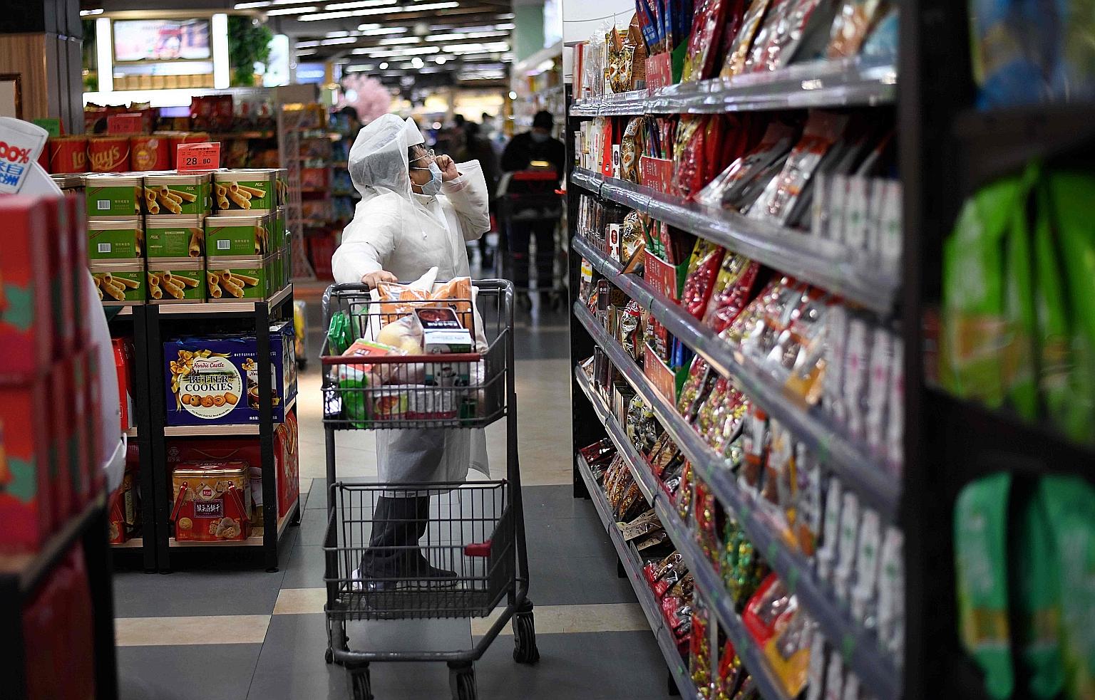 A woman shopping in a supermarket in Wuhan on March 30. In China, some grocery upstarts, including Yonghui Superstores and Alibaba's Hema supermarket chain, have started worker-sharing pacts. Hema told local media that such workforce arrangements mig