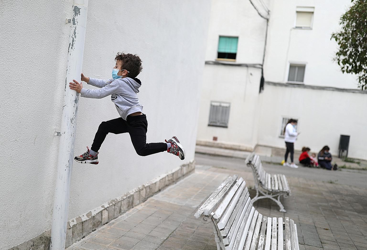 Six-year-old Kilian wearing a face mask as he jumped exuberantly outdoors after Spain on Sunday lifted curbs partially for children aged under 14 during the coronavirus outbreak. PHOTO: REUTERS