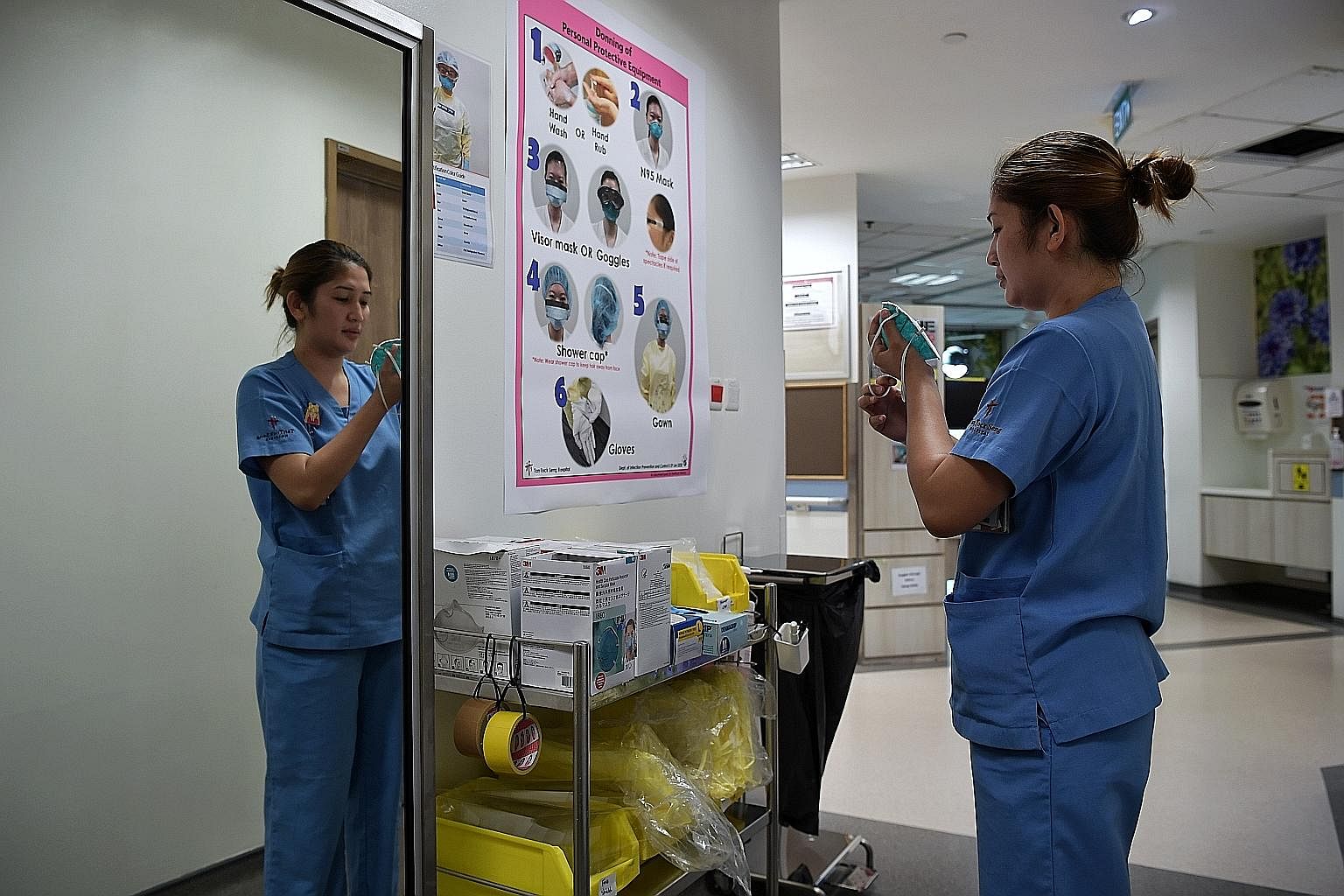 A nurse preparing to don her personal protective gear. Tan Tock Seng Hospital is one of the hospitals that have had to cope with the spike in infection cases in Singapore. ST PHOTO: KUA CHEE SIONG Exhaust fans installed at the windows in a Covid-19 w