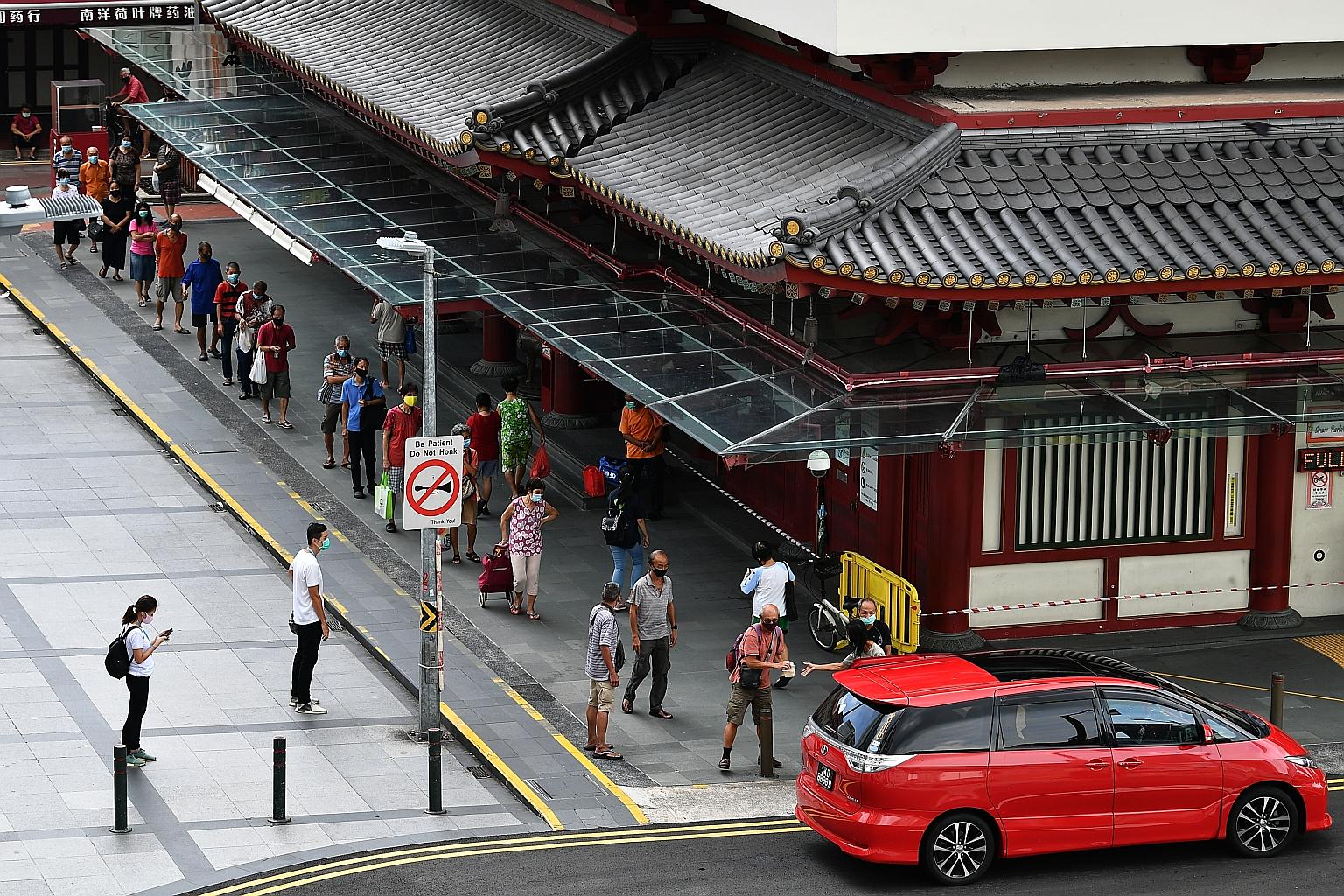 Dozens queued up yesterday outside the Buddha Tooth Relic Temple in Chinatown for free meals, distributed by restaurateur Bernard Teo, 39, and his cousin Amanda Ng, 46, a hairstylist. They have been distributing free meals to the elderly outside the 