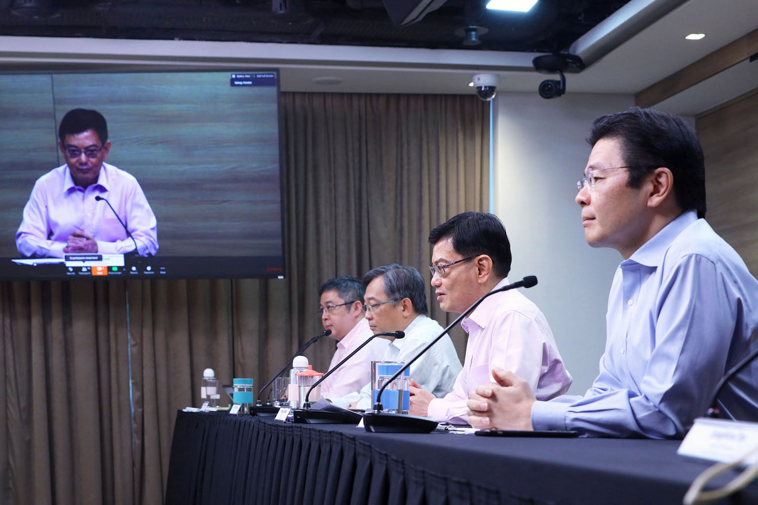Below: Workers at S11 Dormitory. A fourth wave emerged around March 30 when foreign workers started coming down with the virus. Right: Deputy Prime Minister Heng Swee Keat joining a virtual press conference by the multi-ministry task force on April 2