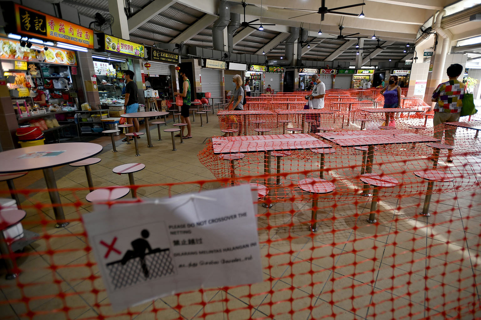 Patrons observing safe distancing while queueing for food at Tampines Round Market & Food Centre last Tuesday. This is part of the Government's precautionary measures for public health amid the coronavirus pandemic.