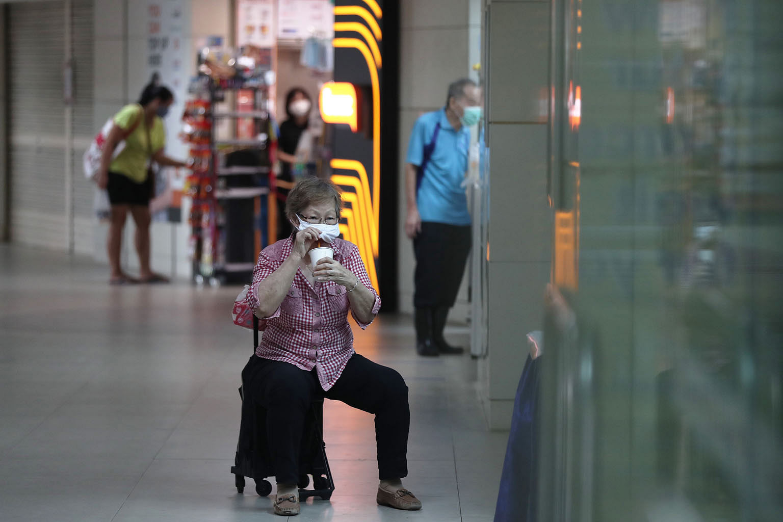 A woman resting on her trolley chair at Clementi bus interchange last Thursday. Tighter restrictions on the movement and gathering of people have thinned out crowds at public places. 