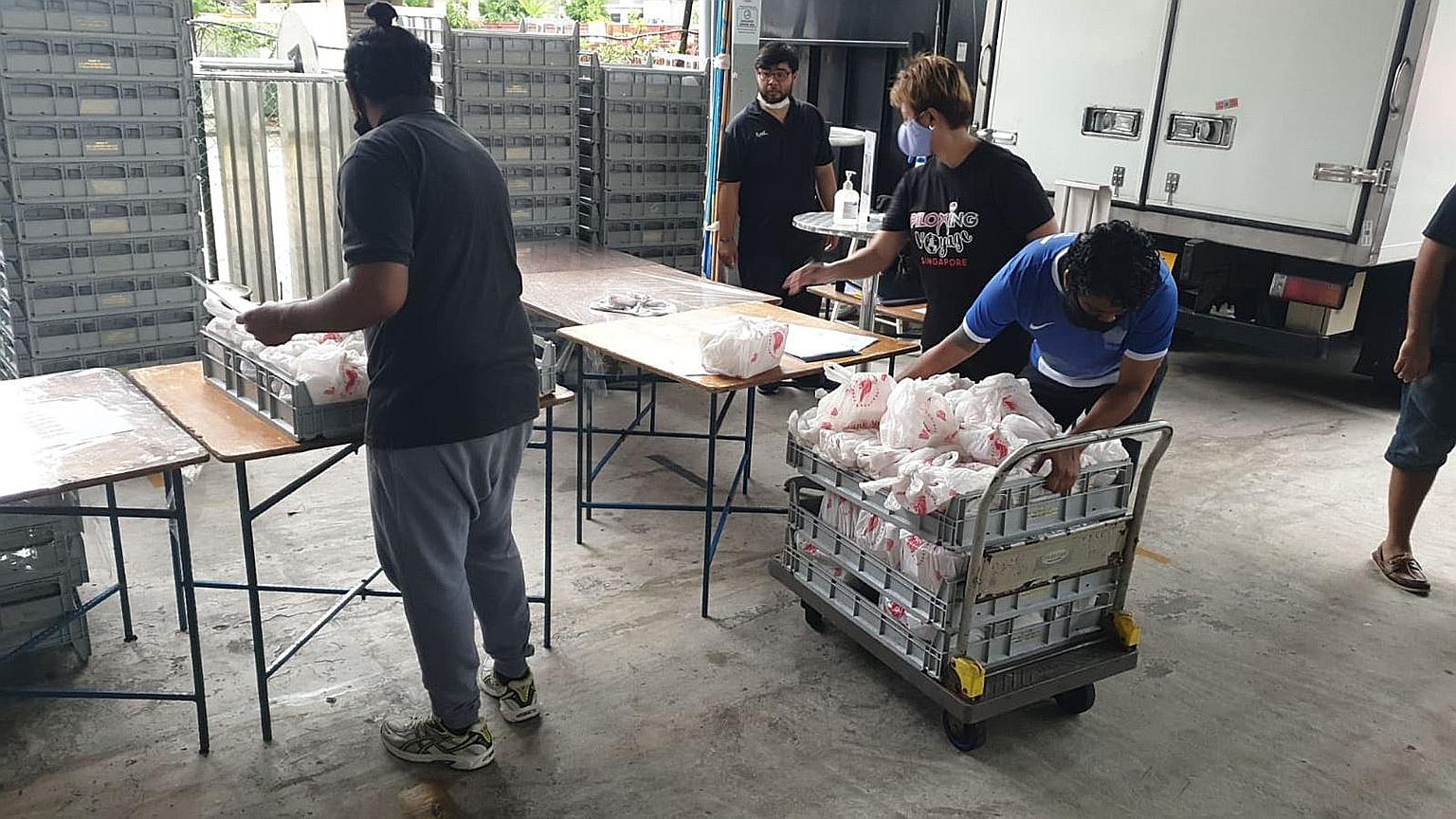 Employees of UAV SG sorting and loading meals into vehicles for delivery. The audio-visual lighting and logistics firm now sends meals to low-income families and foreign workers quarantined in dormitories.