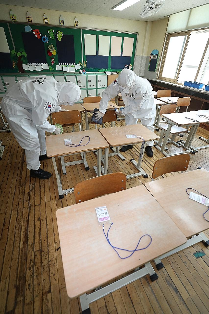 Army personnel disinfecting a classroom at an elementary school in Daegu, South Korea, last Friday. High school seniors will be the first to return to school on May 13, while the rest will follow in phases as schools reopen.