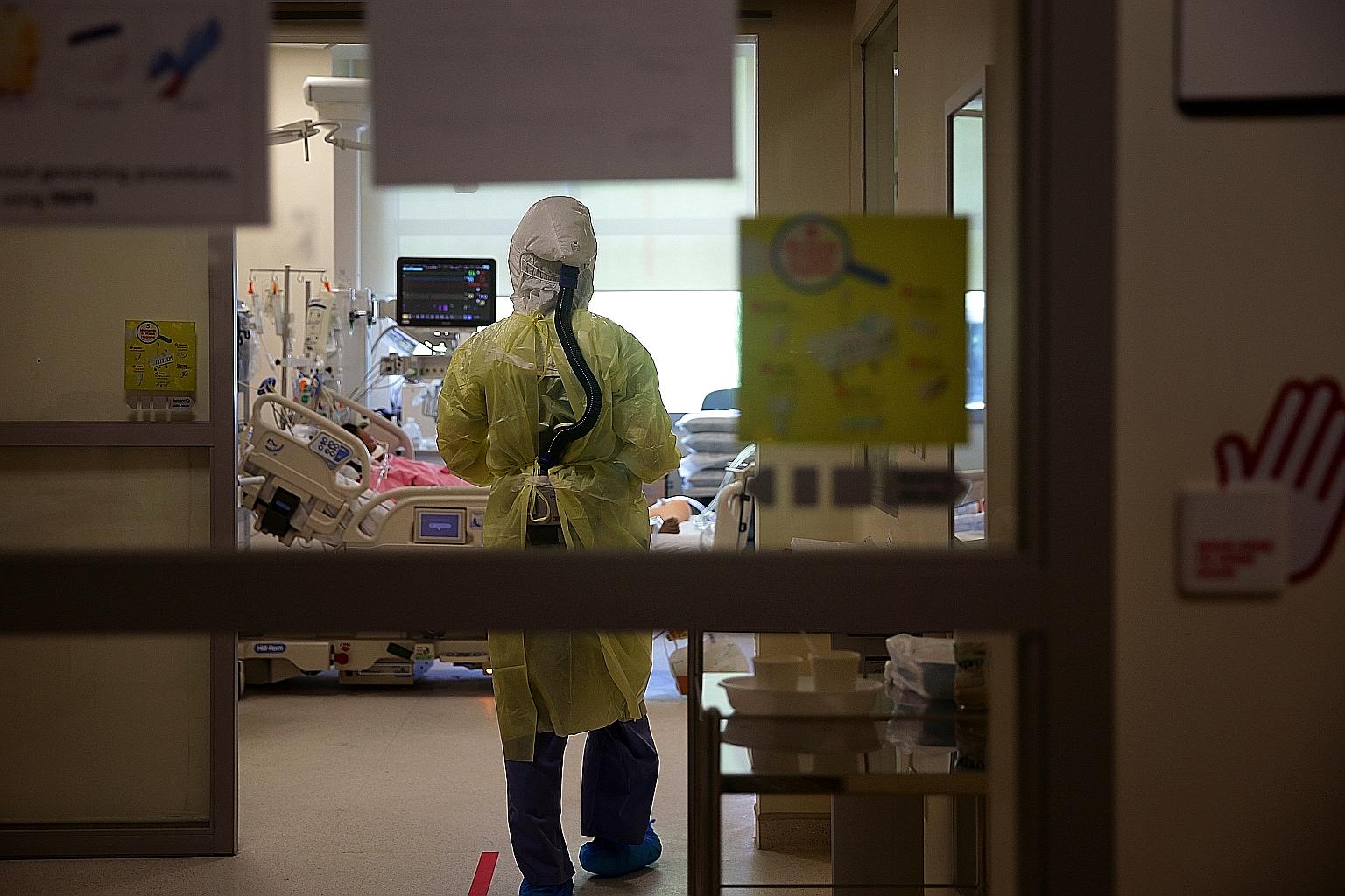 A doctor at Ng Teng Fong General Hospital entering the negative pressure room of the intensive care unit to check on a Covid-19 patient last month. Singapore has around 150 vacant intensive care beds and can quickly bring another 300 on board, said H