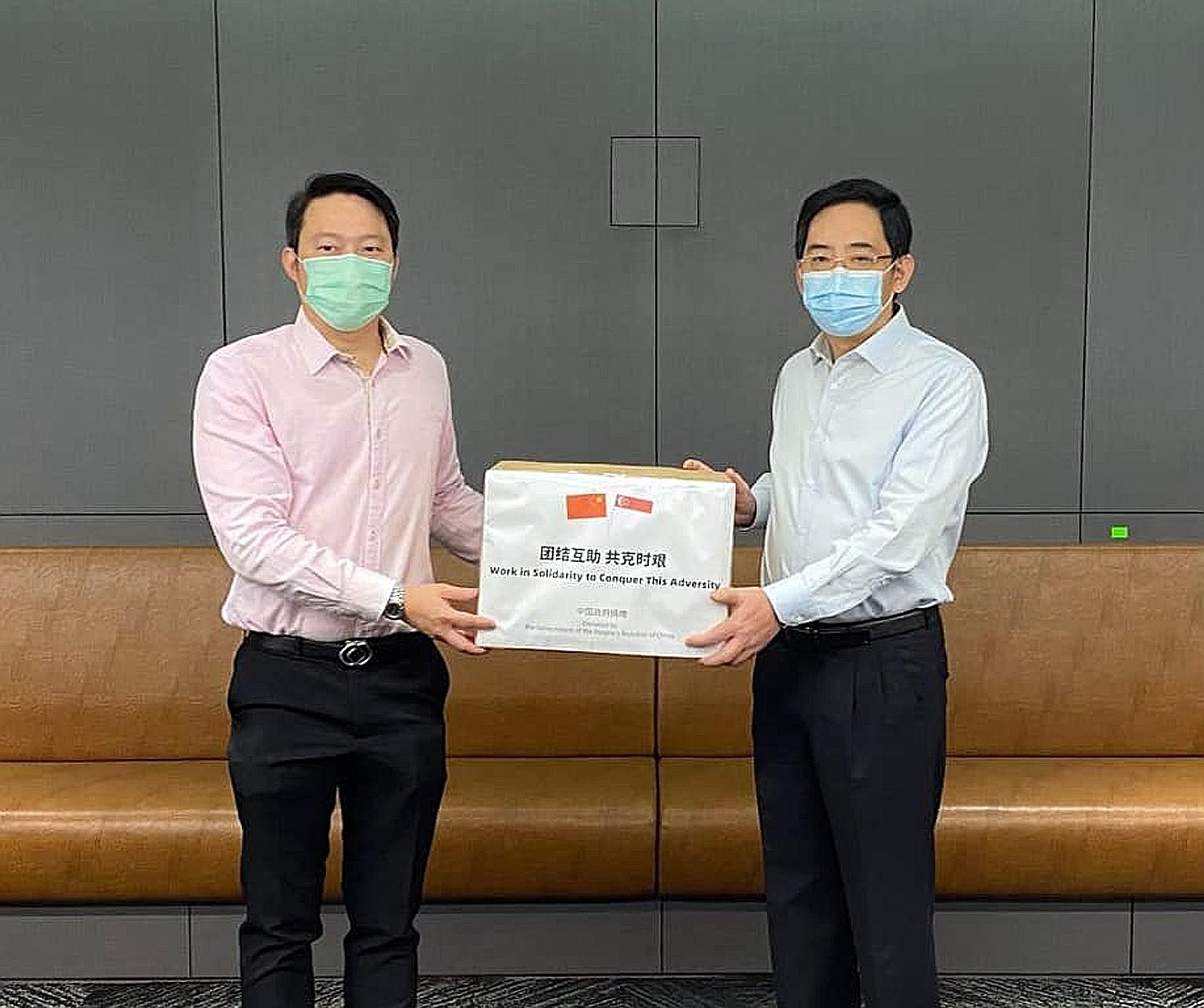 Senior Minister of State for Health Lam Pin Min (left) receiving a donation of masks from China's Ambassador to Singapore Hong Xiaoyong at the Ministry of Health yesterday.