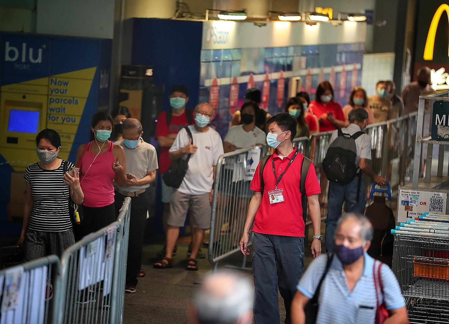 A safe distancing ambassador at work at Clementi Mall on Monday. The attack on Monday has raised concerns among these ambassadors, who ensure safe distancing at parks, malls and other public areas daily. ST PHOTO: KELVIN CHNG