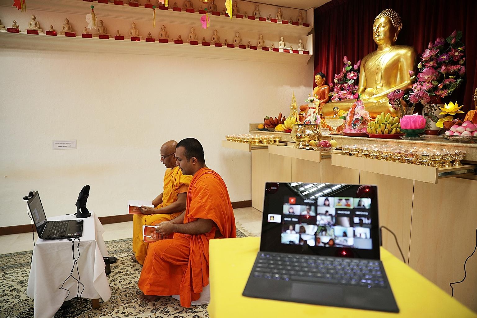 Singapore Buddhist Mission's Venerable K. Dhammika Maha Thera (left) and Venerable T. Chandima Thera conducting Pali chanting for a virtual audience yesterday, as Buddhists went online to commemorate Vesak Day.